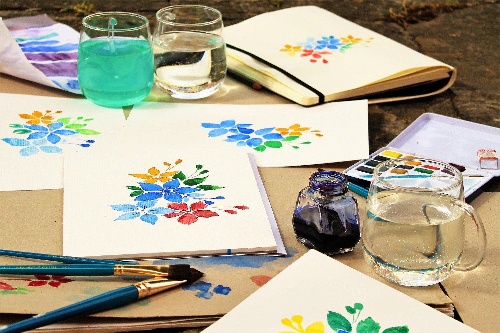 Mesa con pinturas y lienzos.