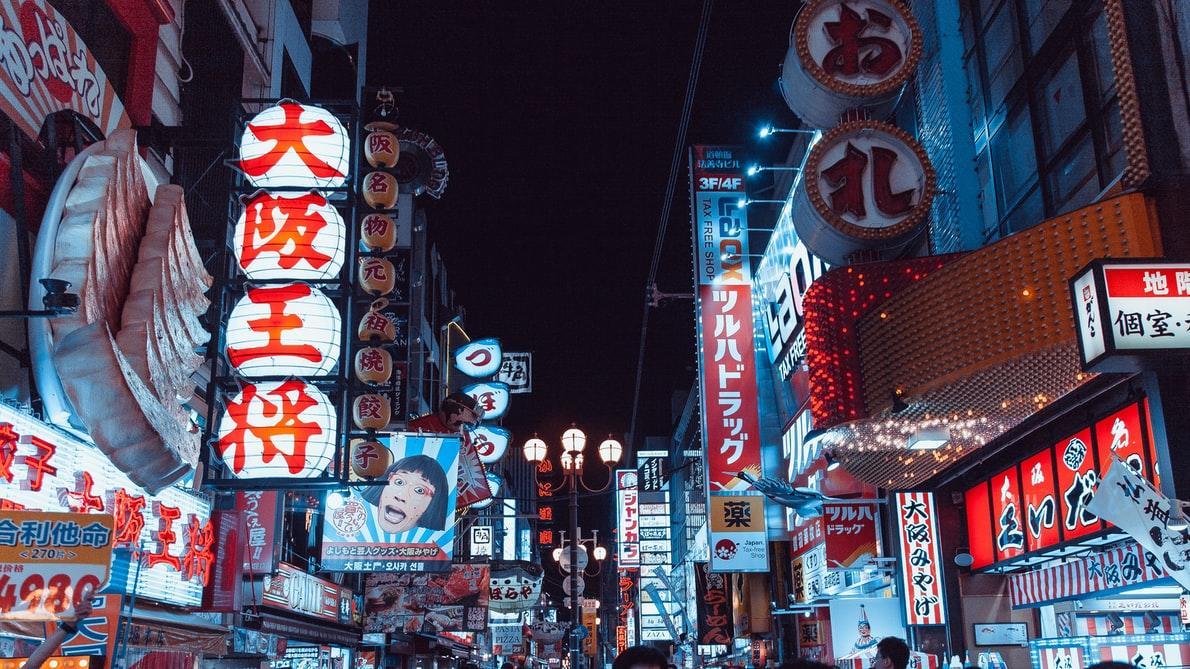 Calle típica de una urbe japonesa de noche con muchos carteles iluminados