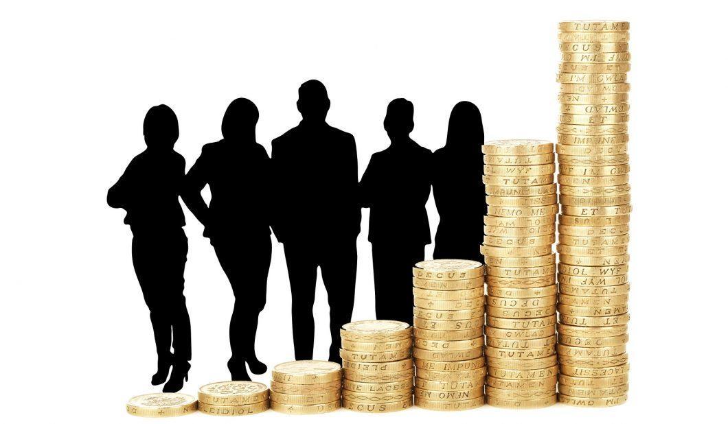 Escala hecha con monedas y atrás la silueta de 5 personas