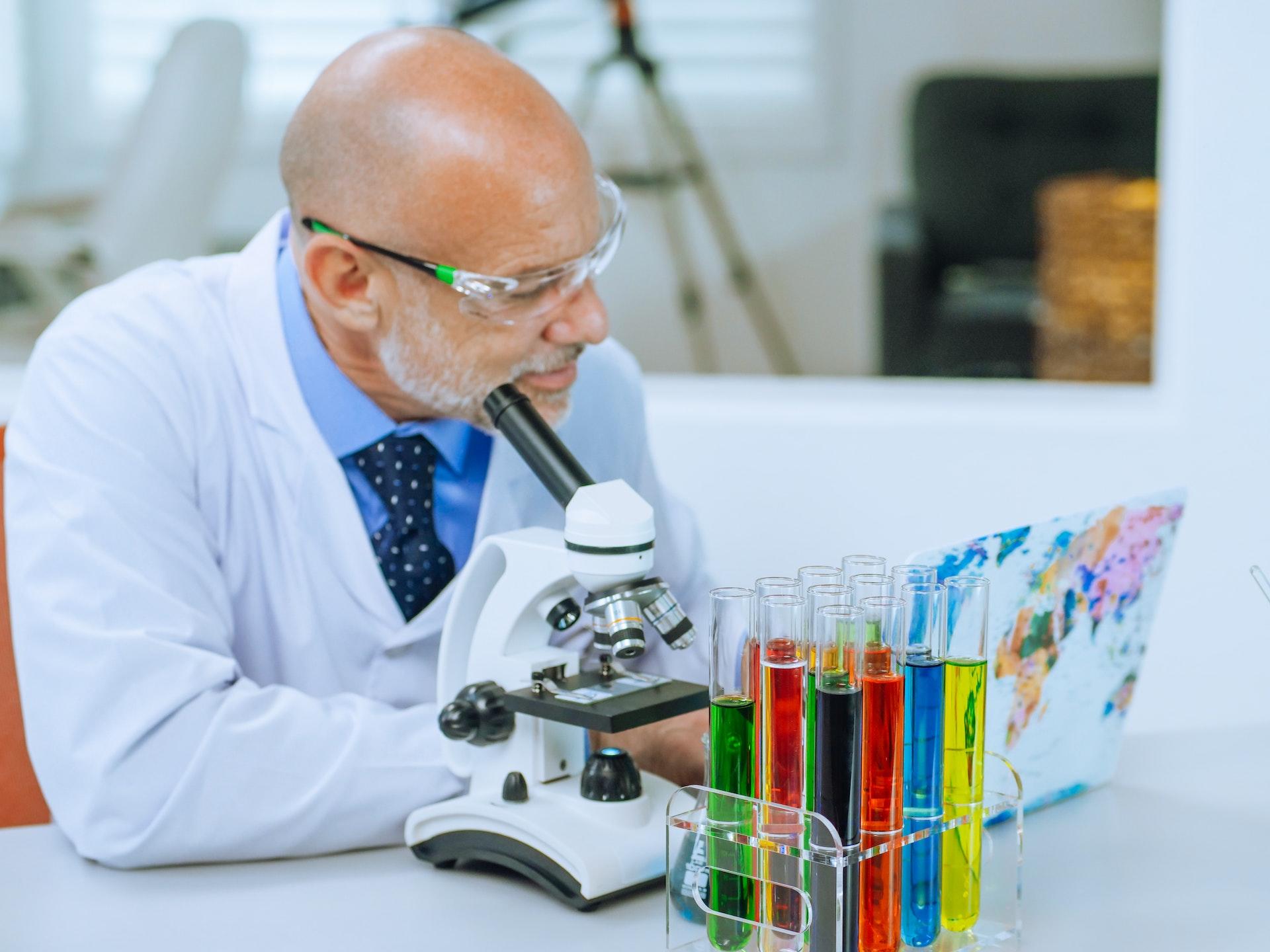 Hombre en el laboratorio con un microscopio.