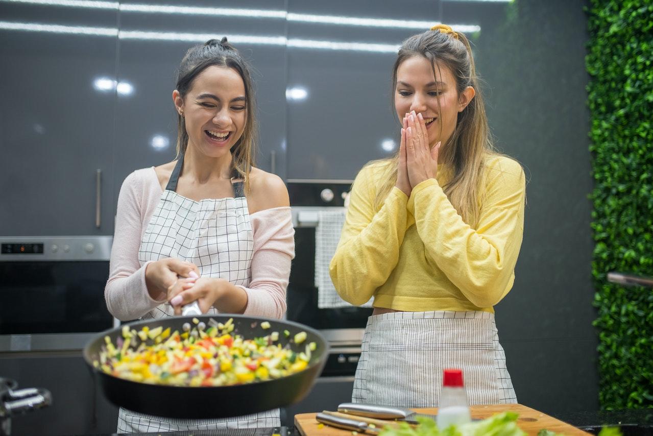 Chicas cocinando y riendo.