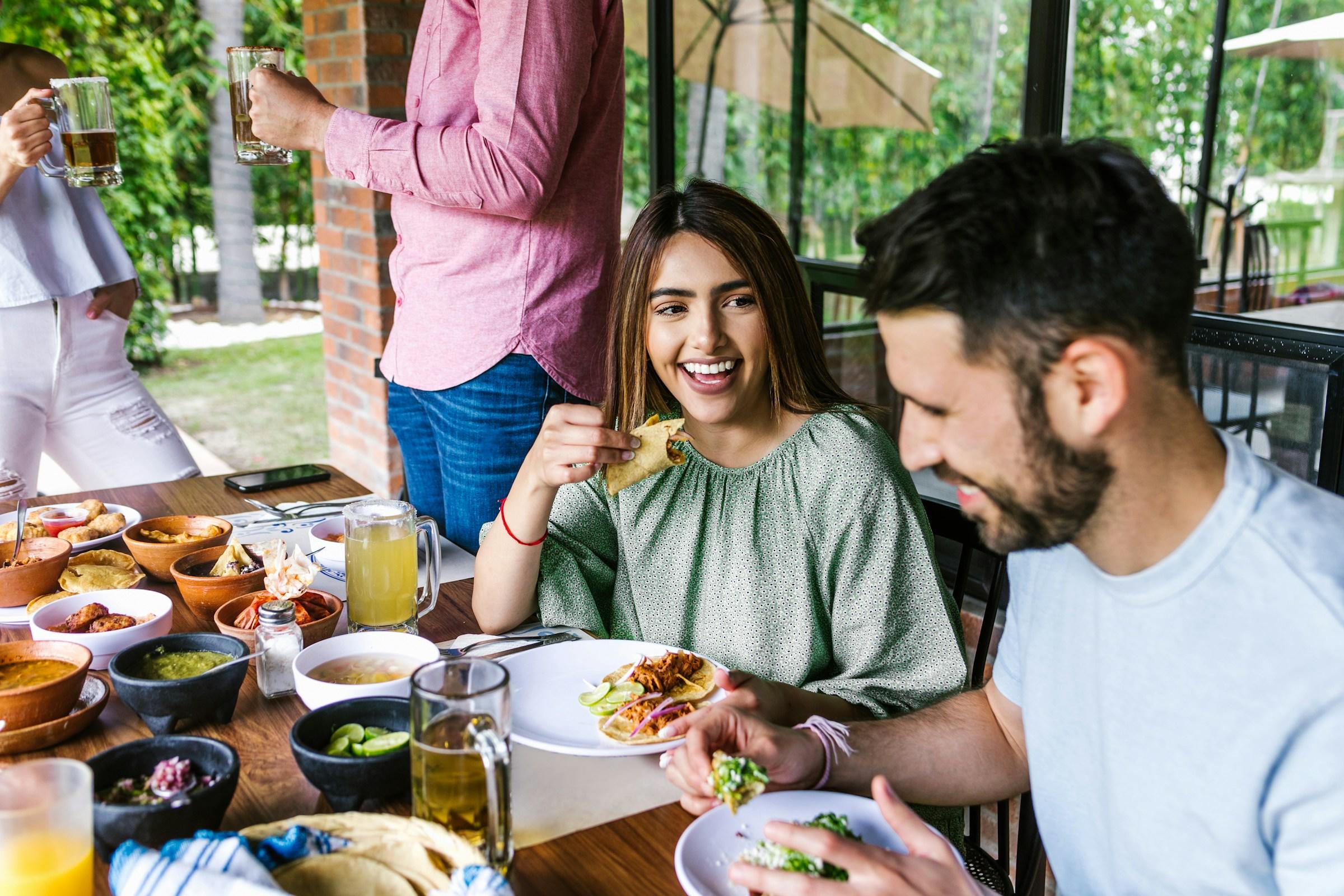 Amigos comiendo comida mexicana.