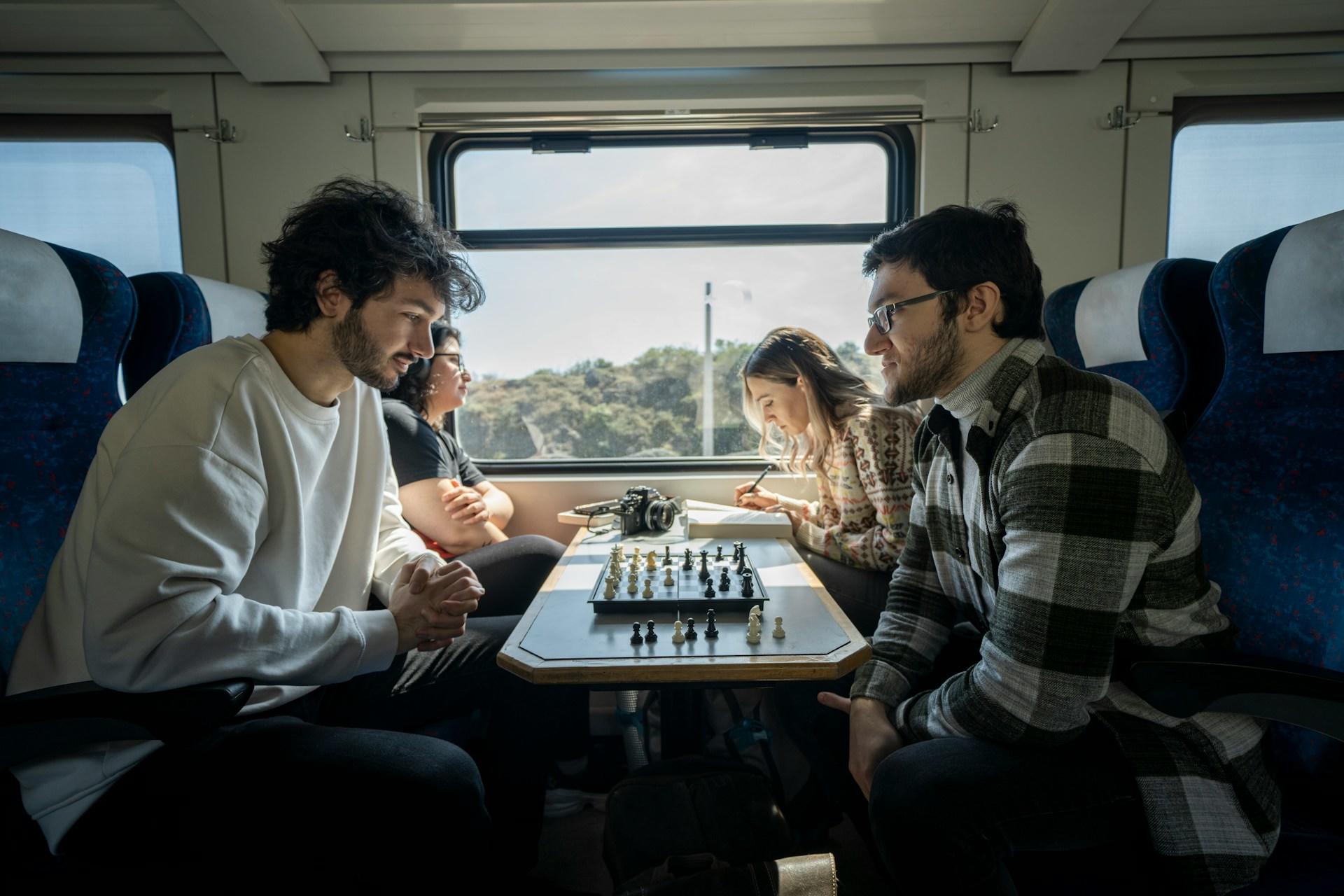 Amigos jugando al ajedrez en el tren.