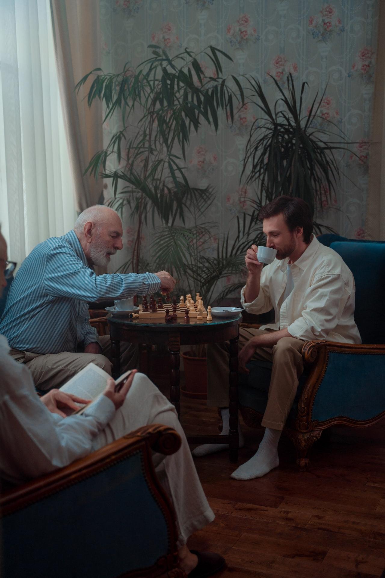Dos personas jugando al ajedrez en una cafetería.