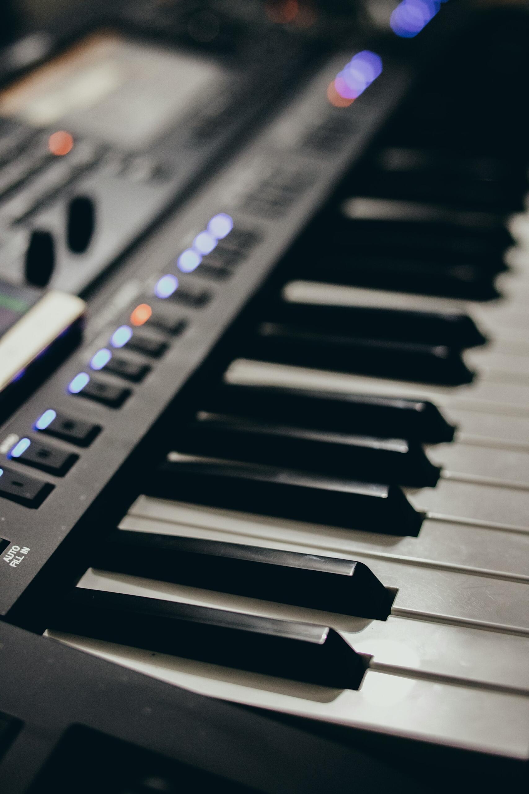 Un primer plano de un teclado electrónico, que muestra un equipo musical moderno para componer o practicar.