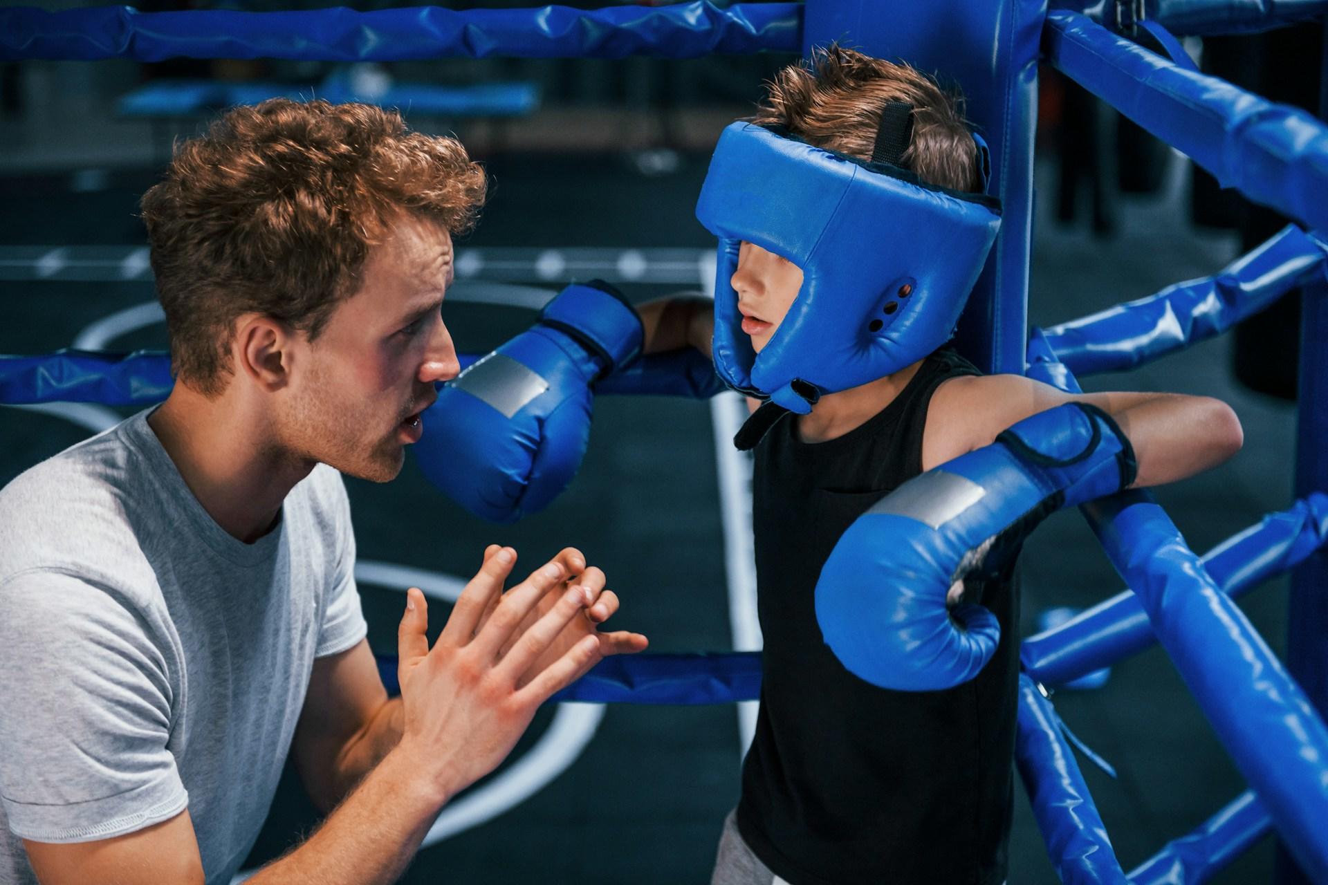 Niño aprendiendo a boxear con un instructor.