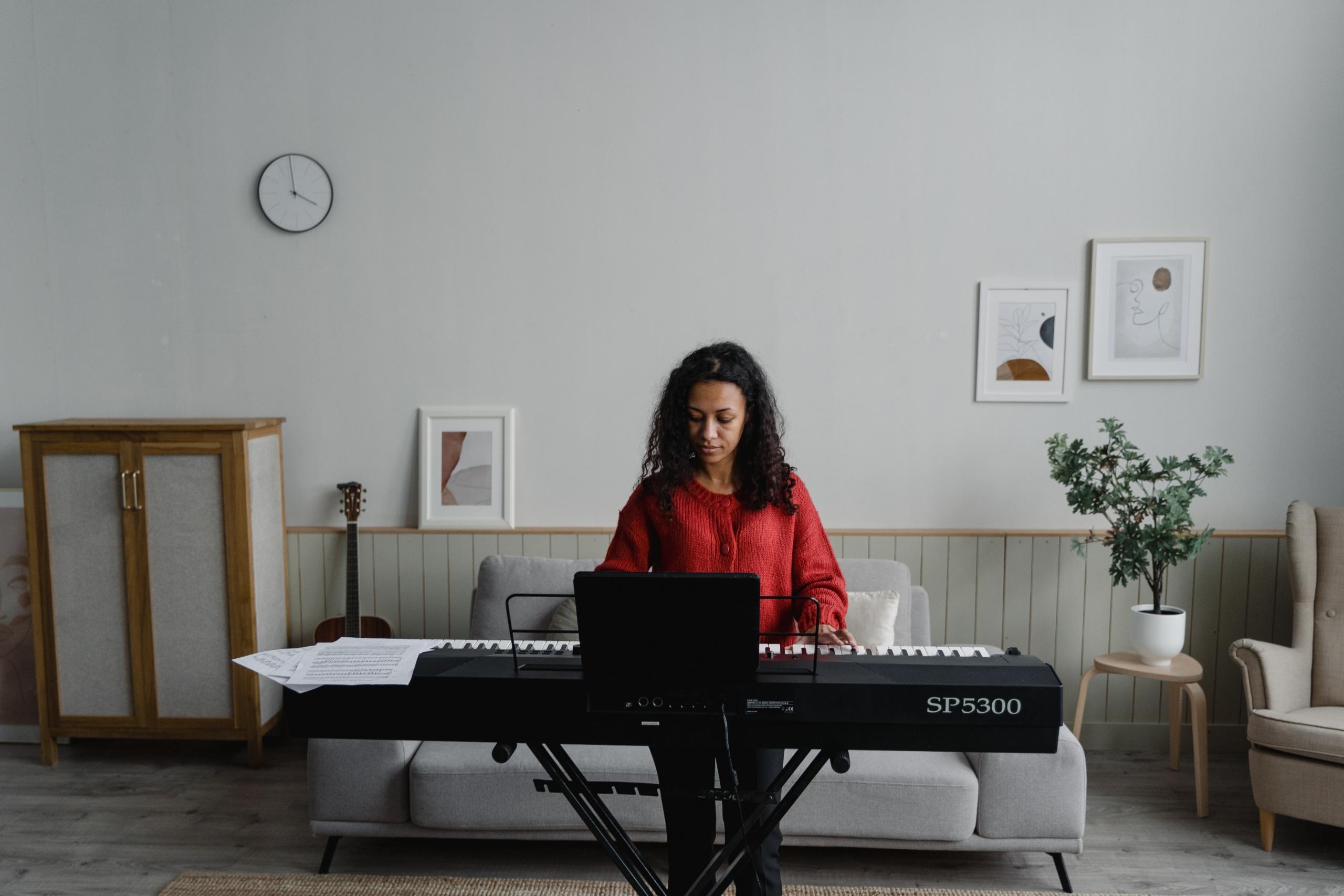 Mujer tocando el piano en su casa.