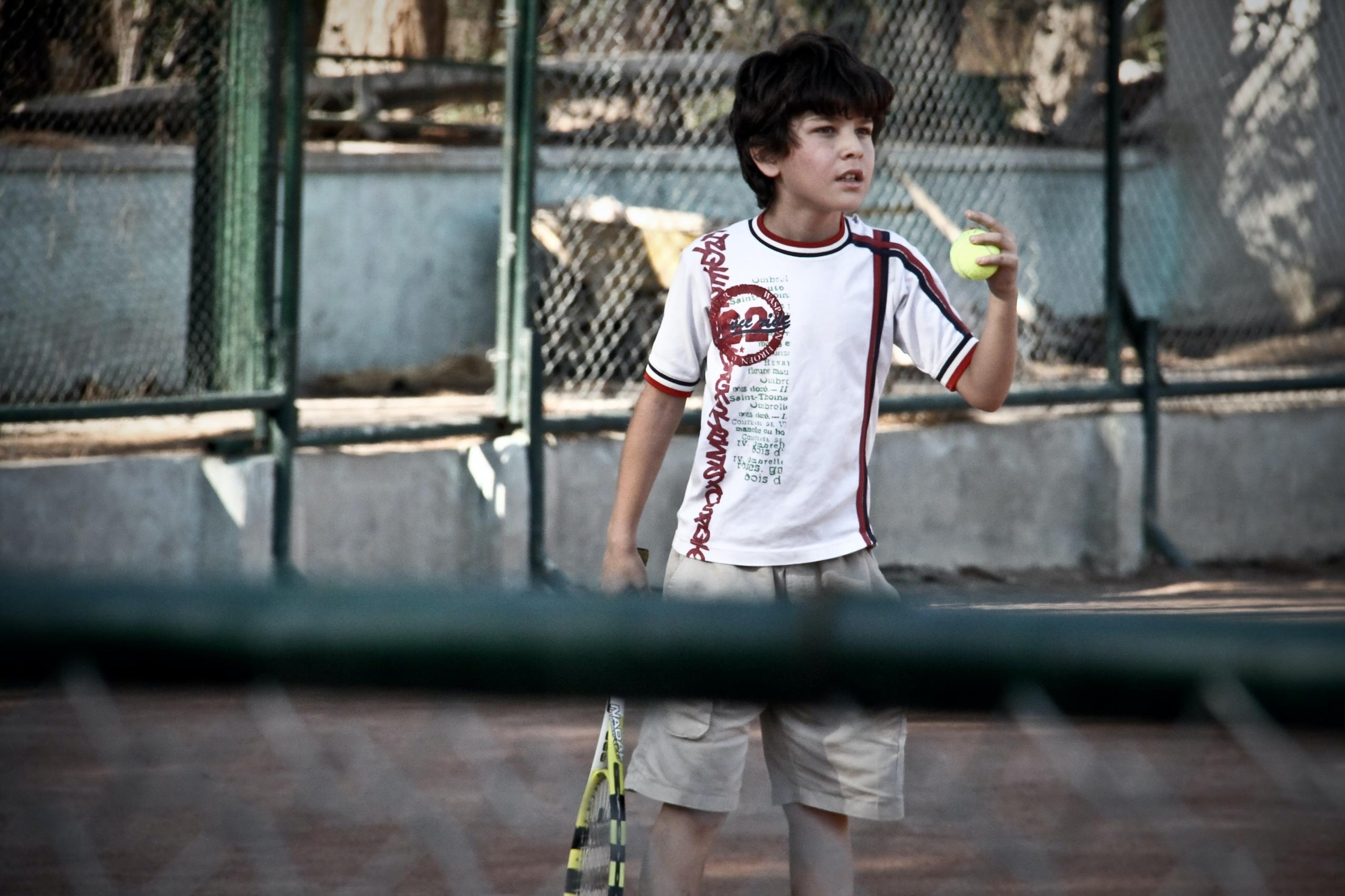 Niño jugando al tenis.