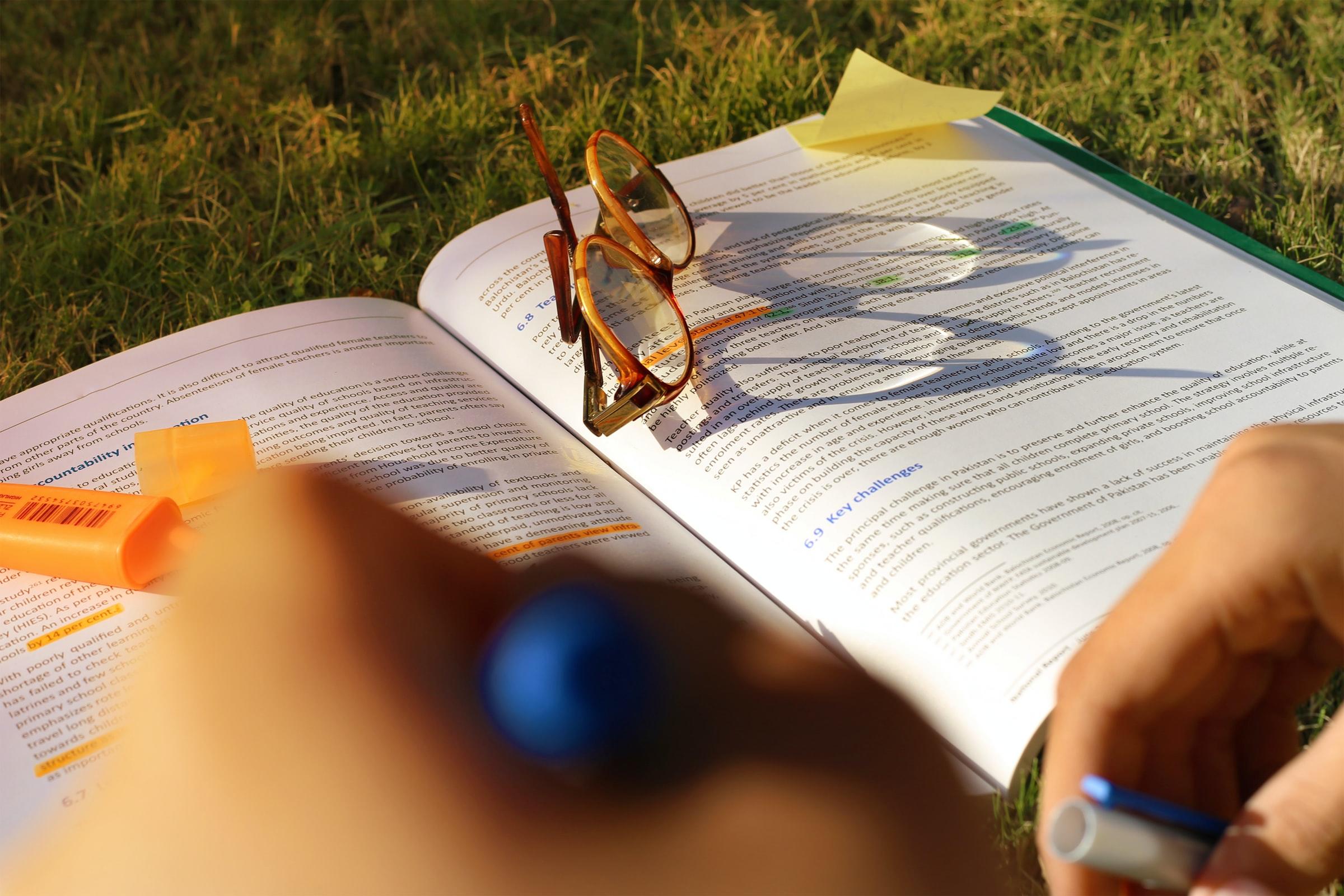 libro abierto de alumno con lentes encima