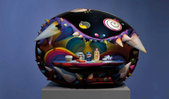 Una escultura abstracta y colorida que se asemeja a una criatura con grandes púas blancas y patrones en espiral. En su interior, los condimentos y los pequeños objetos crean una escena peculiar y divertida.