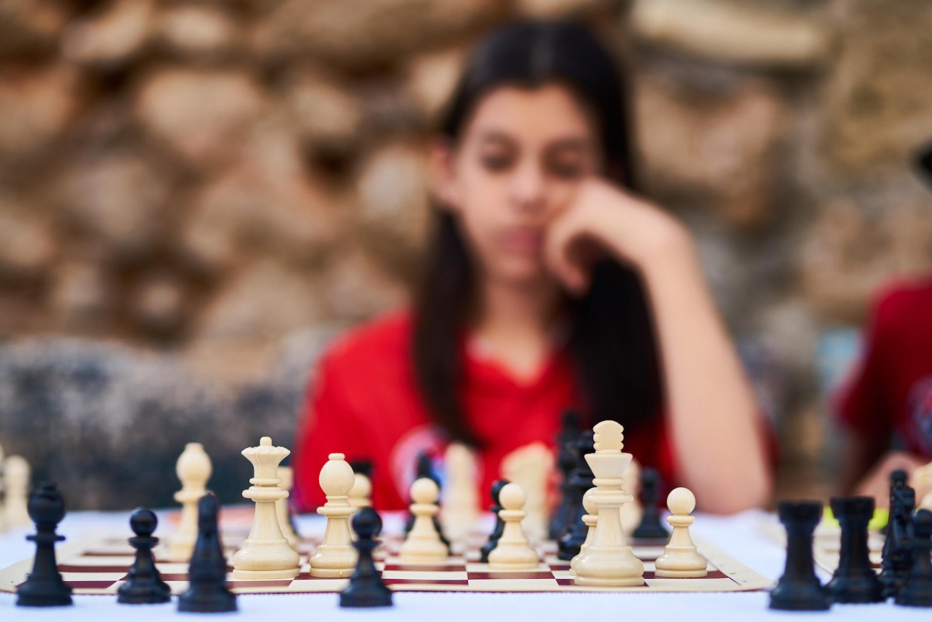 Niña jugando al ajedrez.