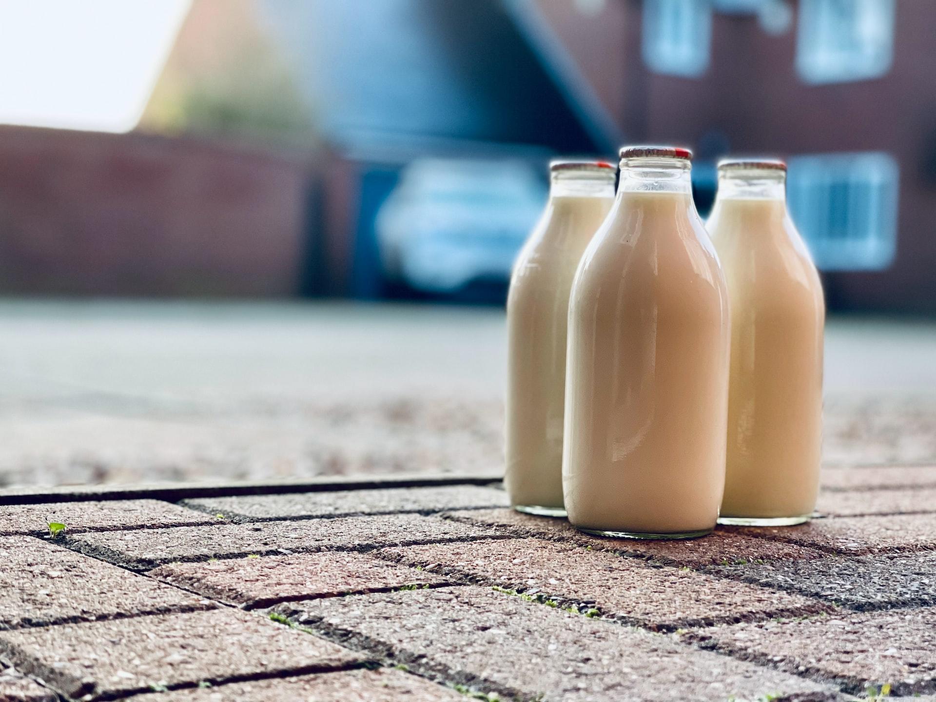 tres botellas de leche en vidrio en la calle
