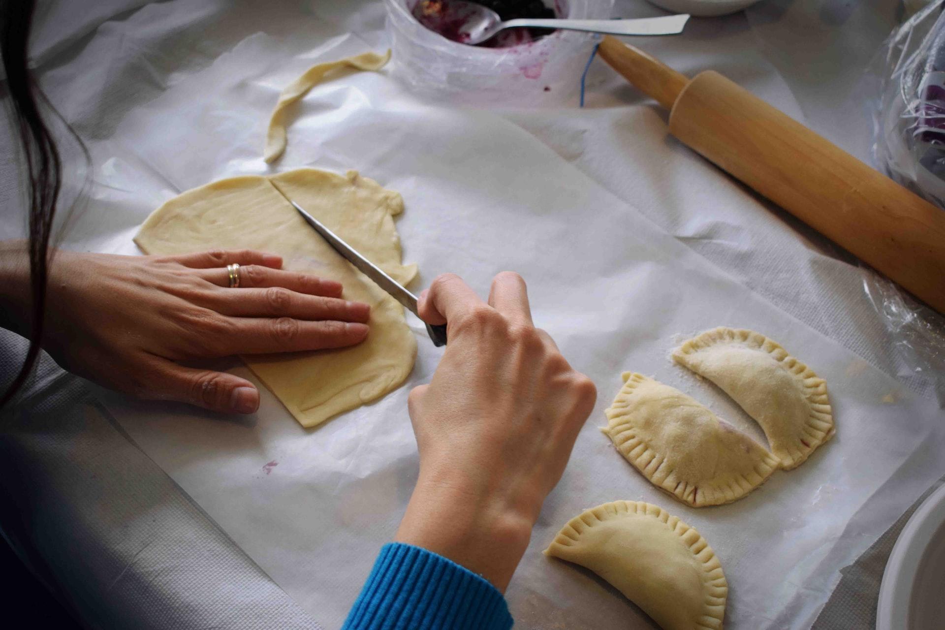 Persona haciendo empanadillas.