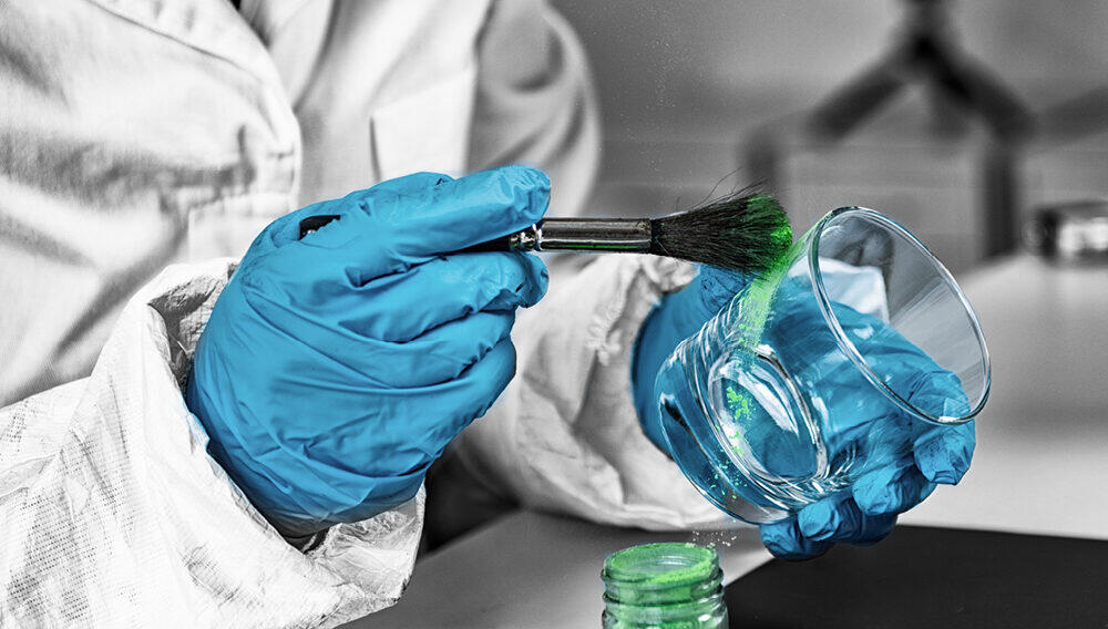 Una persona con bata de laboratorio examina un vaso de precipitados que contiene un líquido de un verde intenso, en lo que constituye un momento de investigación científica.