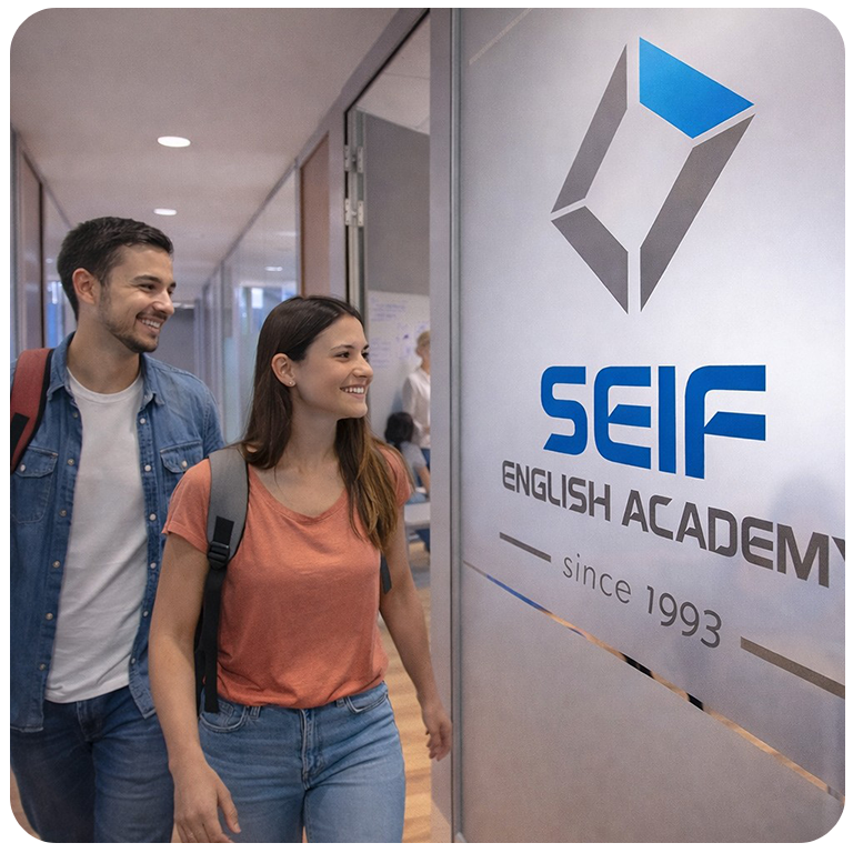 Un hombre y una mujer sonrientes pasan junto a un cartel en el que se lee «SEIF English Academy, desde 1993» en un pasillo moderno, lo que sugiere un ambiente de aprendizaje positivo.