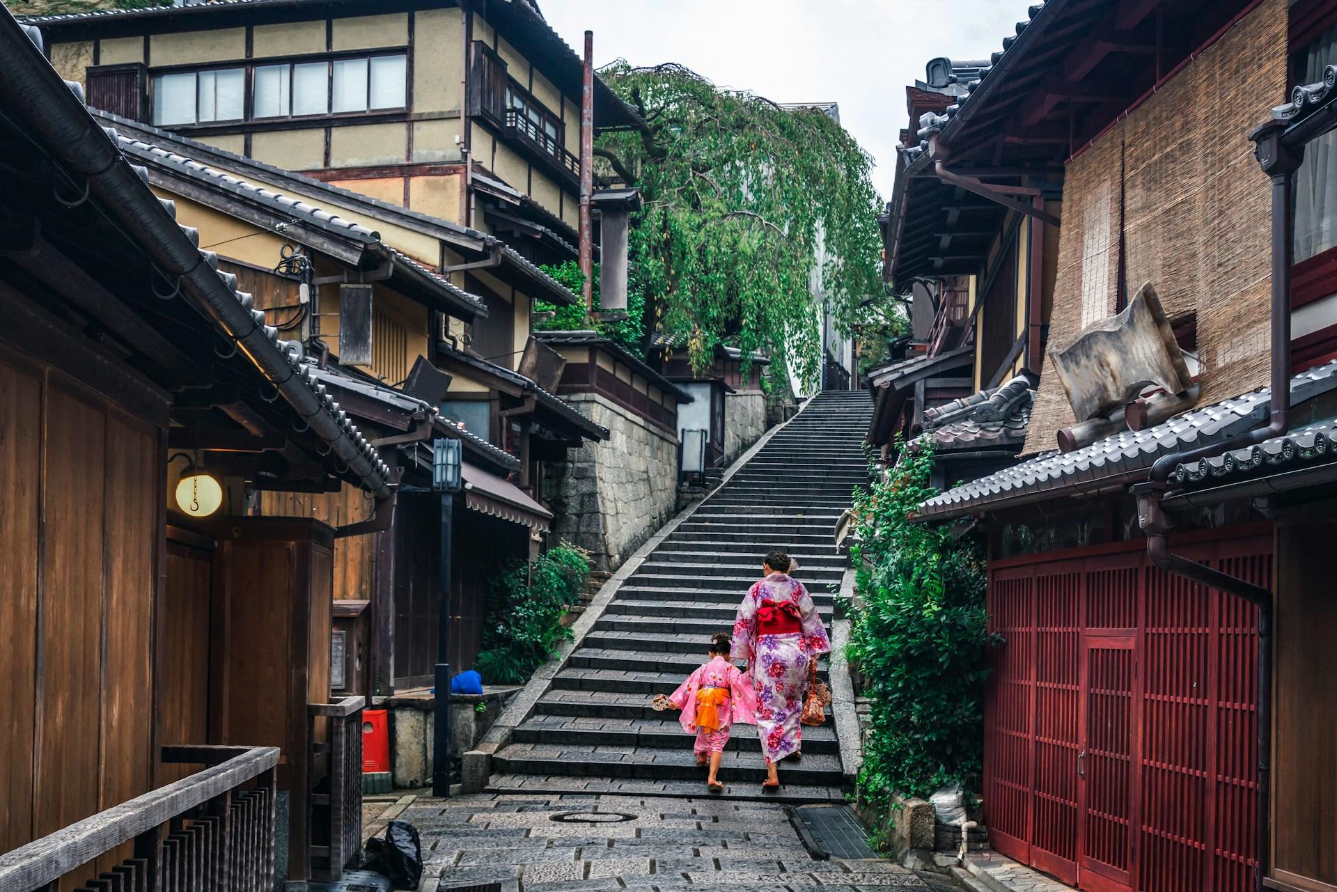una mamá con su hija en vestimenta tradicional japonesa caminando por las calles de kyoto