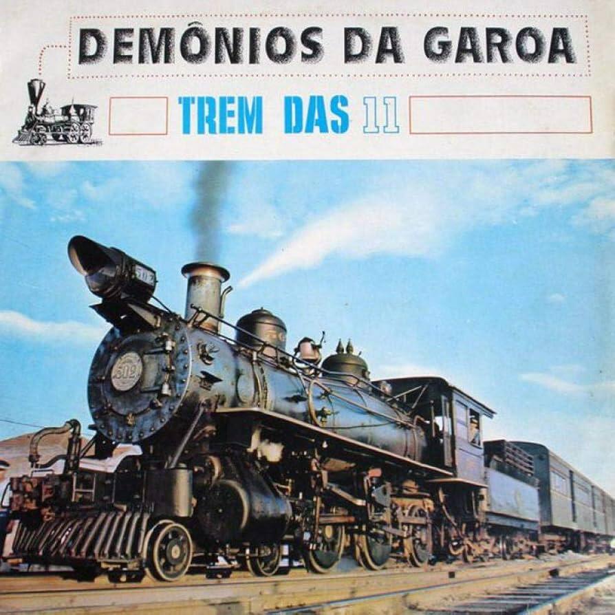 Portada del álbum «Trem das 11» del grupo Demônios da Garoa, que muestra una antigua locomotora de vapor negra sobre raíles bajo un cielo azul, con humo saliendo de la chimenea, vagones acoplados al fondo y el título destacado en la parte superior; incluye una pequeña ilustración de un tren y tipografía retro brasileña.