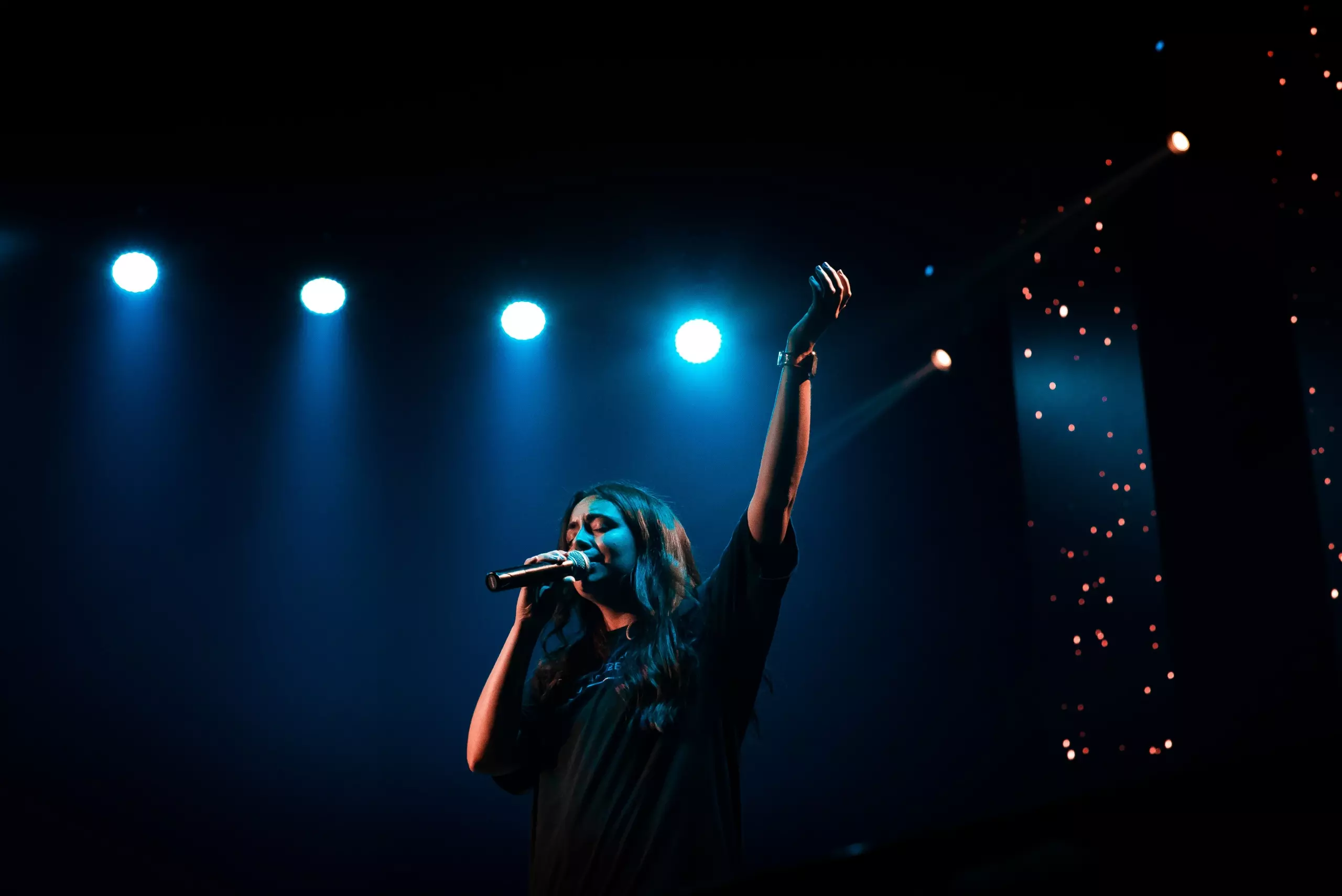 cantante en un escenario azul oscuro