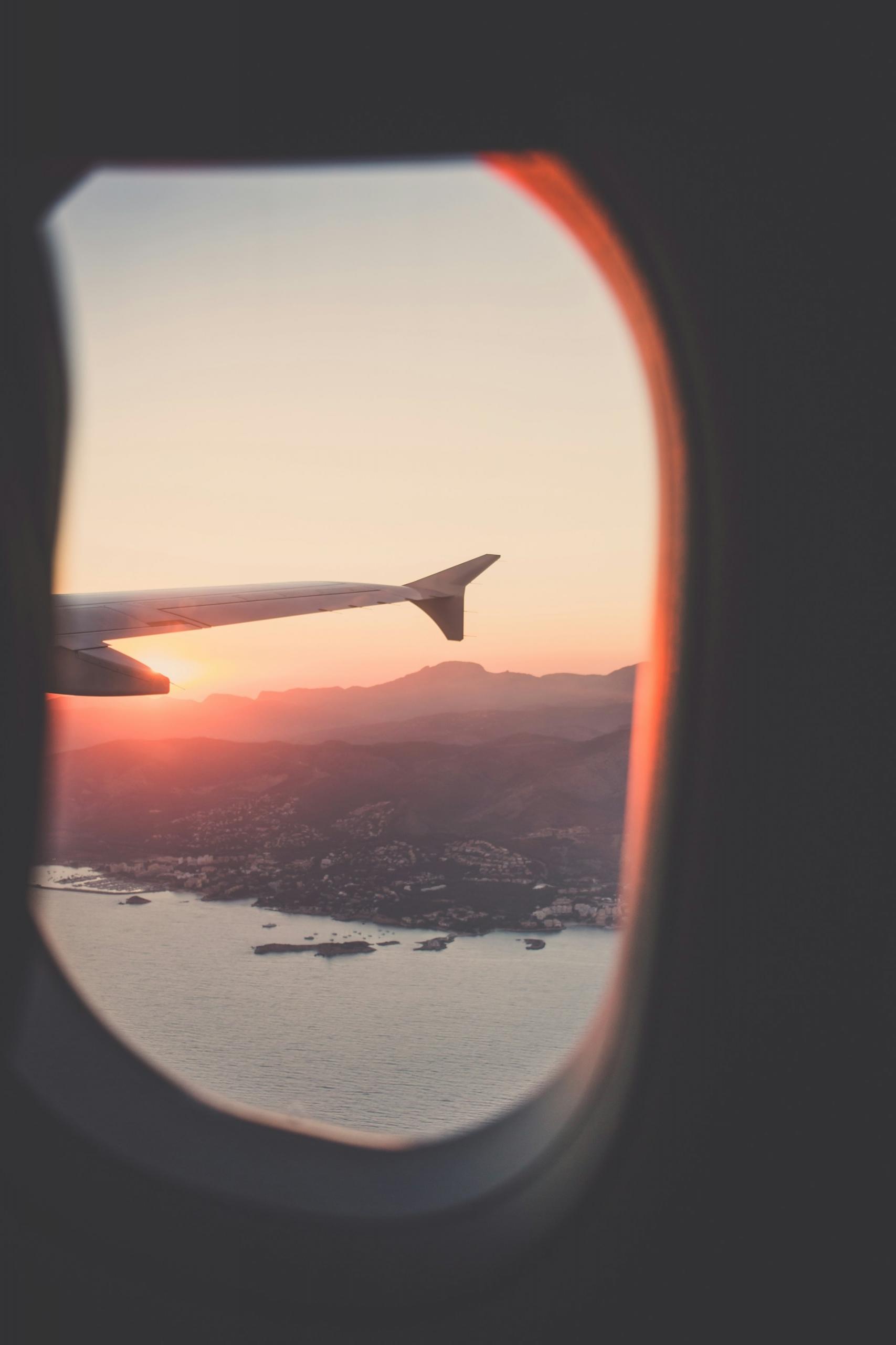 la ventana de un avión viendo el atardecer