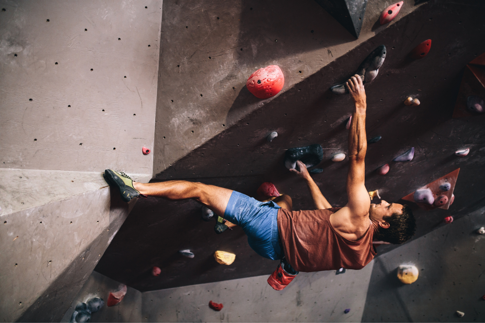 hombre practicando escalada en gimnasio boulder