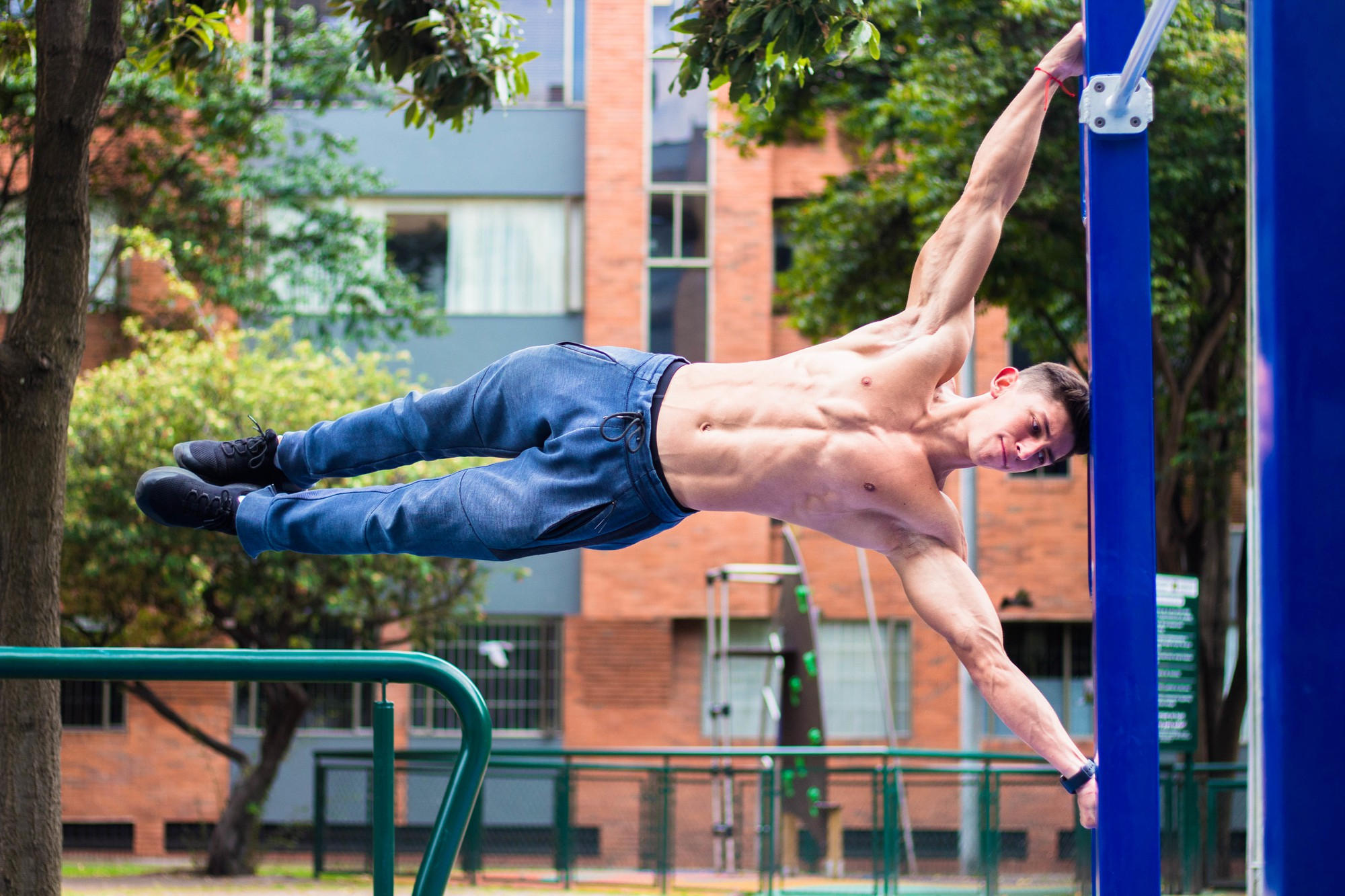 Entrenamiento de calistenia en el parque. Hombre horizontal a las barras