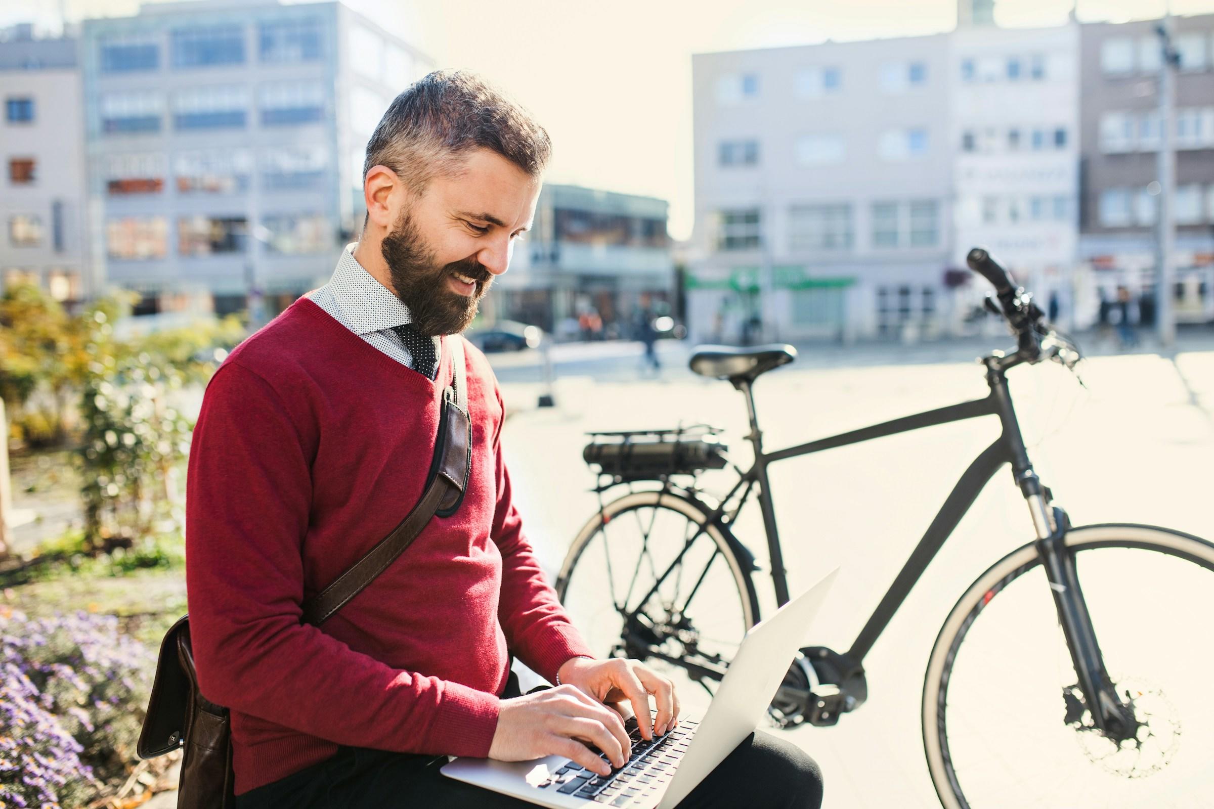 hombre con ordenador y bici