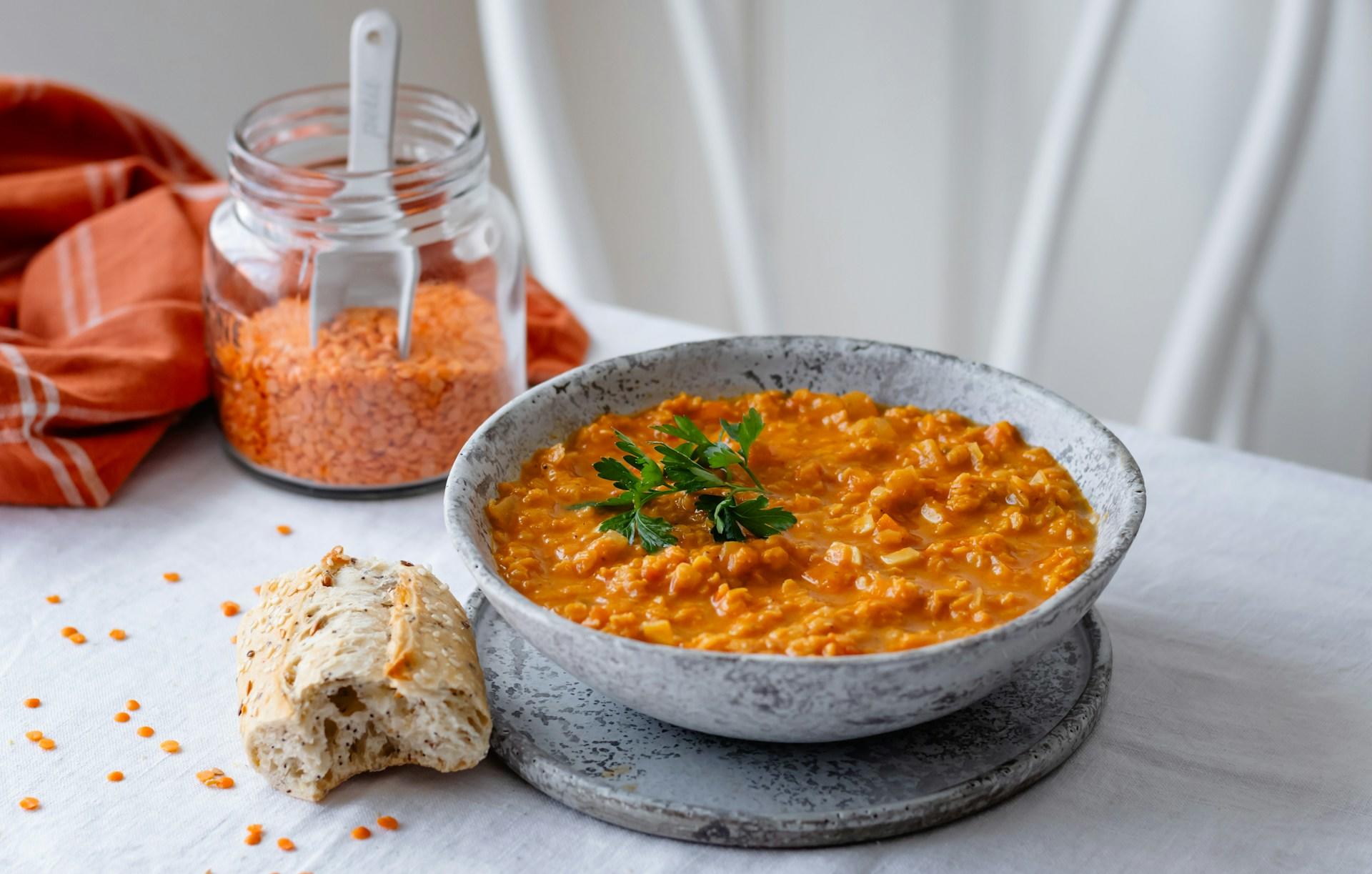 plato de dhal servido con pan en fondo blanco