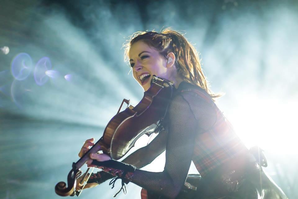 Lindsey Stirling en escena tocando el violín.