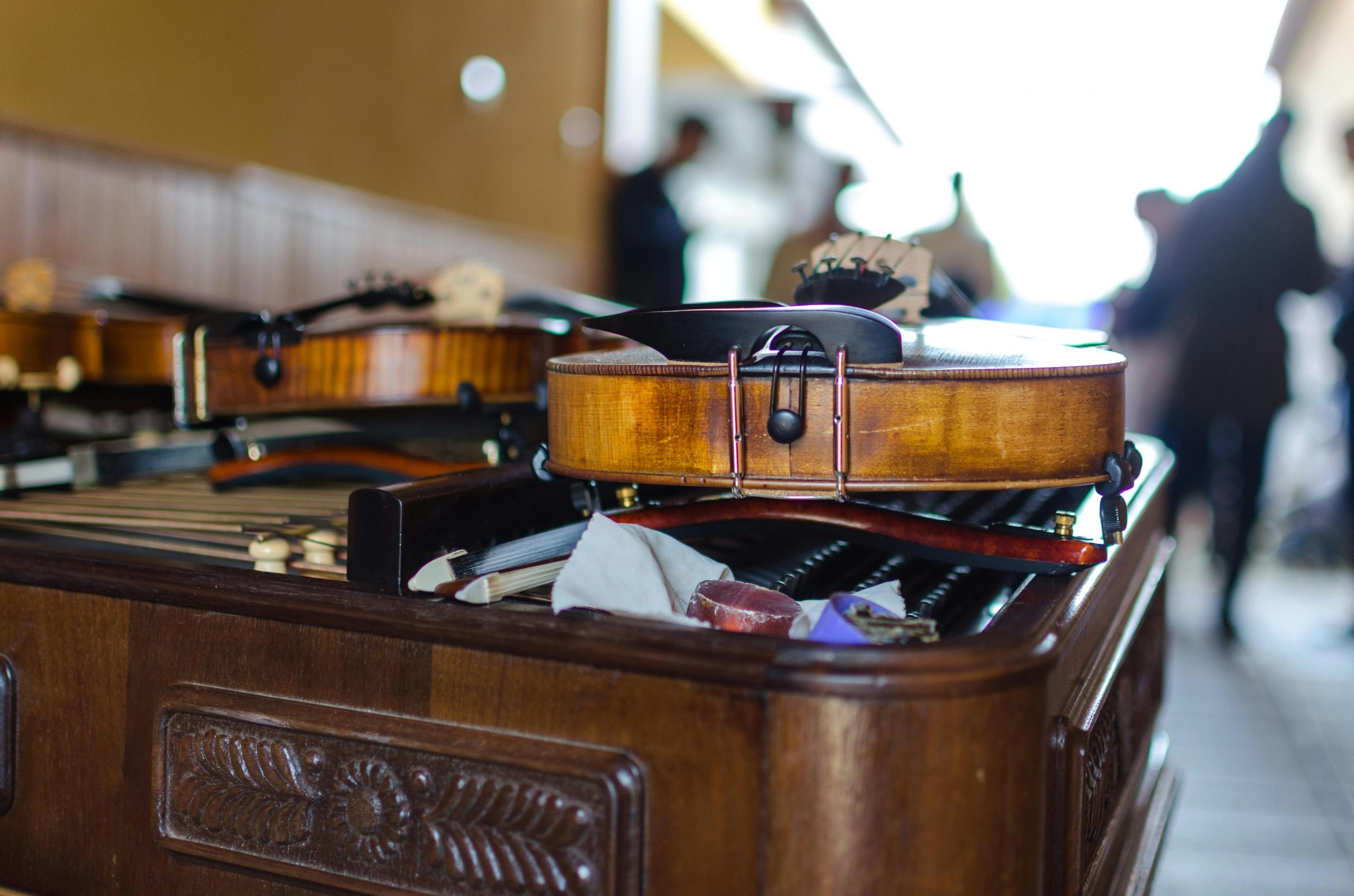 Violines apoyados sobre instrumento de cuerdas.
