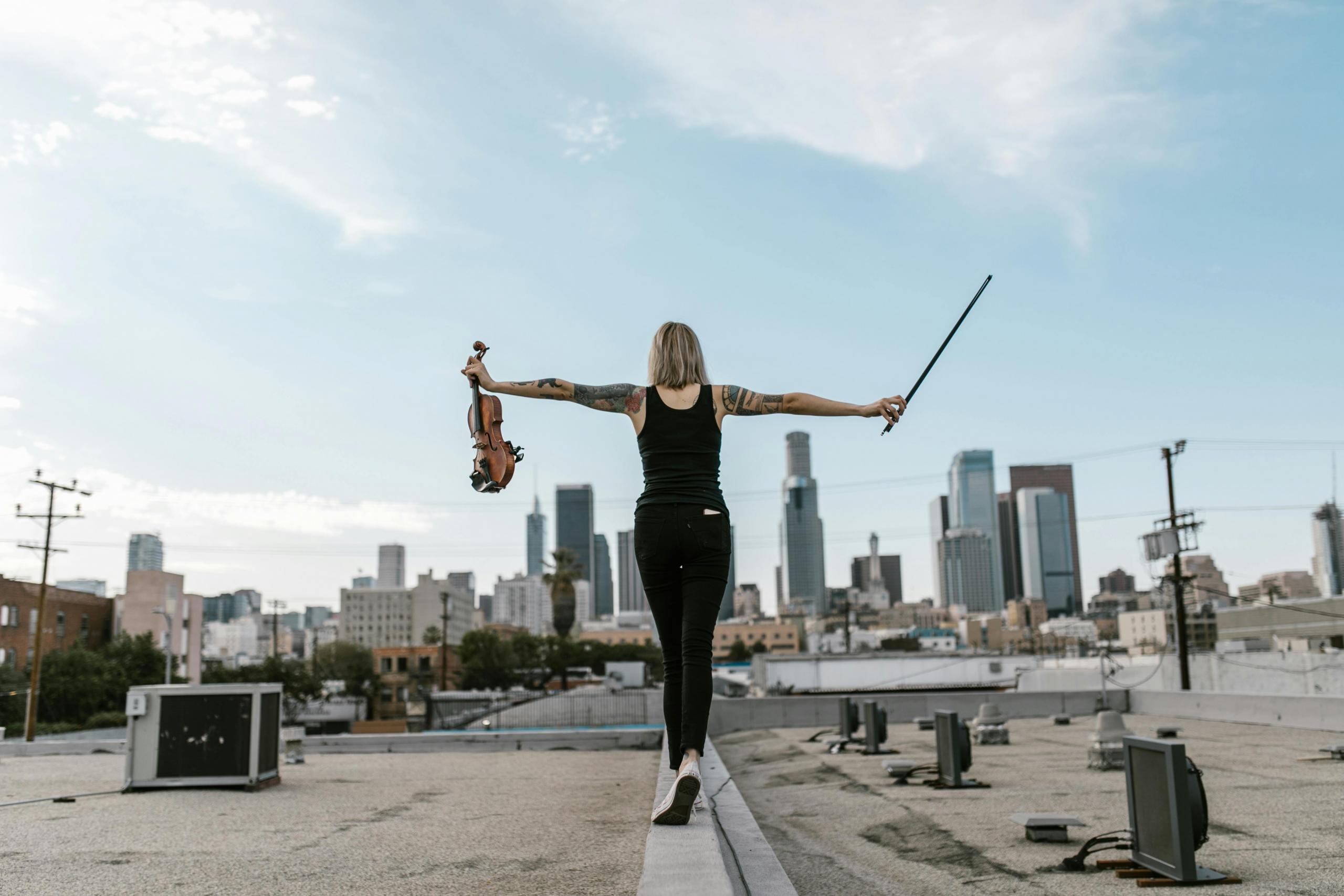 Violinista caminando hacia ciudad