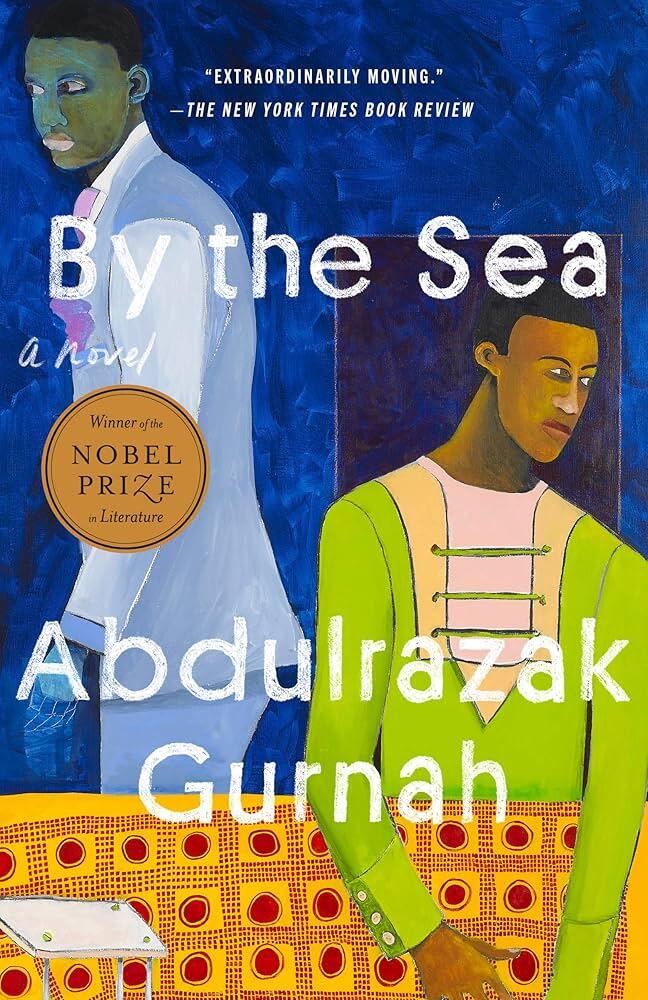 Portada del libro By the Sea, de Abdulrazak Gurnah. Muestra retratos abstractos pintados de dos hombres, uno con traje blanco y otro con camisa verde, con una pegatina dorada del Premio Nobel de Literatura.