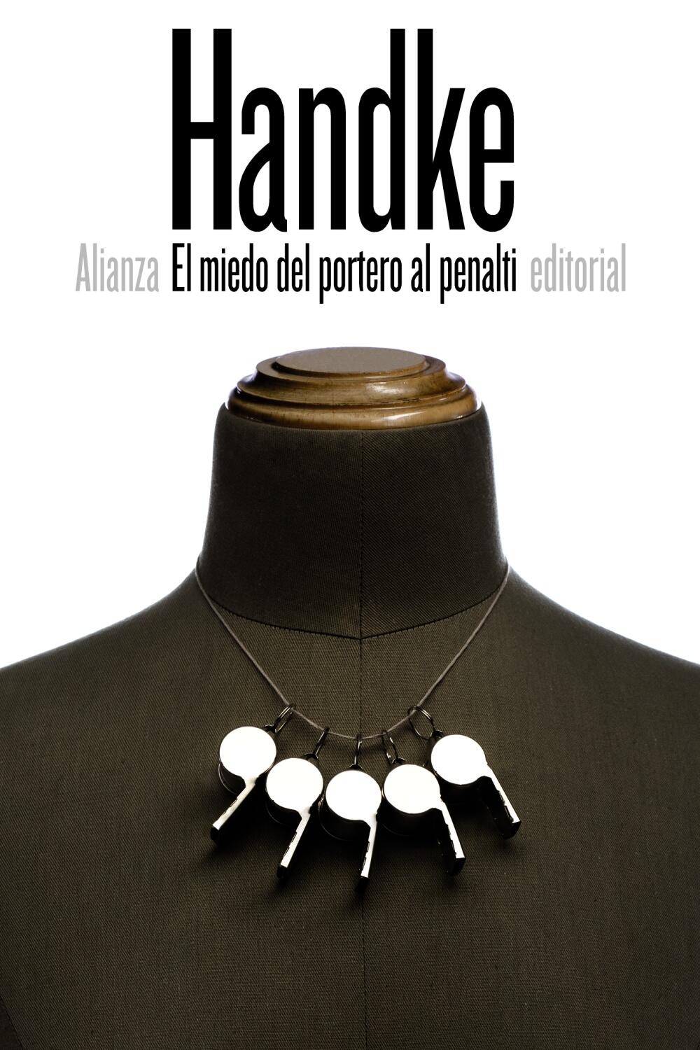 Un maniquí de sastre con un collar compuesto por cuatro silbatos metálicos; encima, un texto grande que dice «Handke» y, debajo, otro más pequeño en español que dice «El miedo del portero al penalti», editorial Alianza.