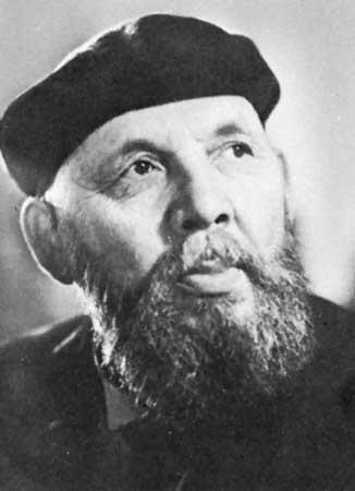 Eemil Sillanpäa con expresión pensativa, que lleva una boina oscura y una barba frondosa, mira hacia arriba. El retrato en blanco y negro tiene un tono contemplativo.