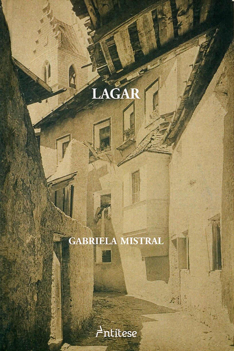 Portada de libro en tonos sepia que muestra un callejón estrecho y rústico entre antiguos edificios de piedra con techos de madera. El texto dice «Lagar», de Gabriela Mistral. El ambiente es nostálgico.