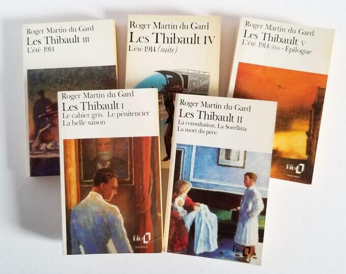 Se exhiben cinco libros franceses de Roger Martin du Gard, titulados «Les Thibault I-V». Las portadas presentan un estilo impresionista, con tonos cálidos y apagados que transmiten una atmósfera clásica y reflexiva.