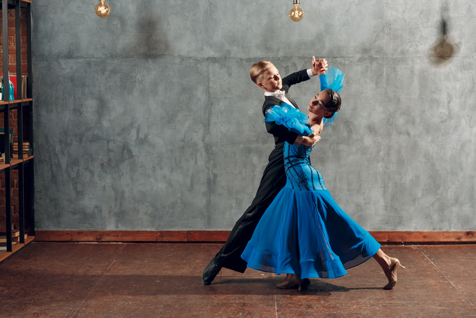 Pareja joven bailando un vals en un estudio.