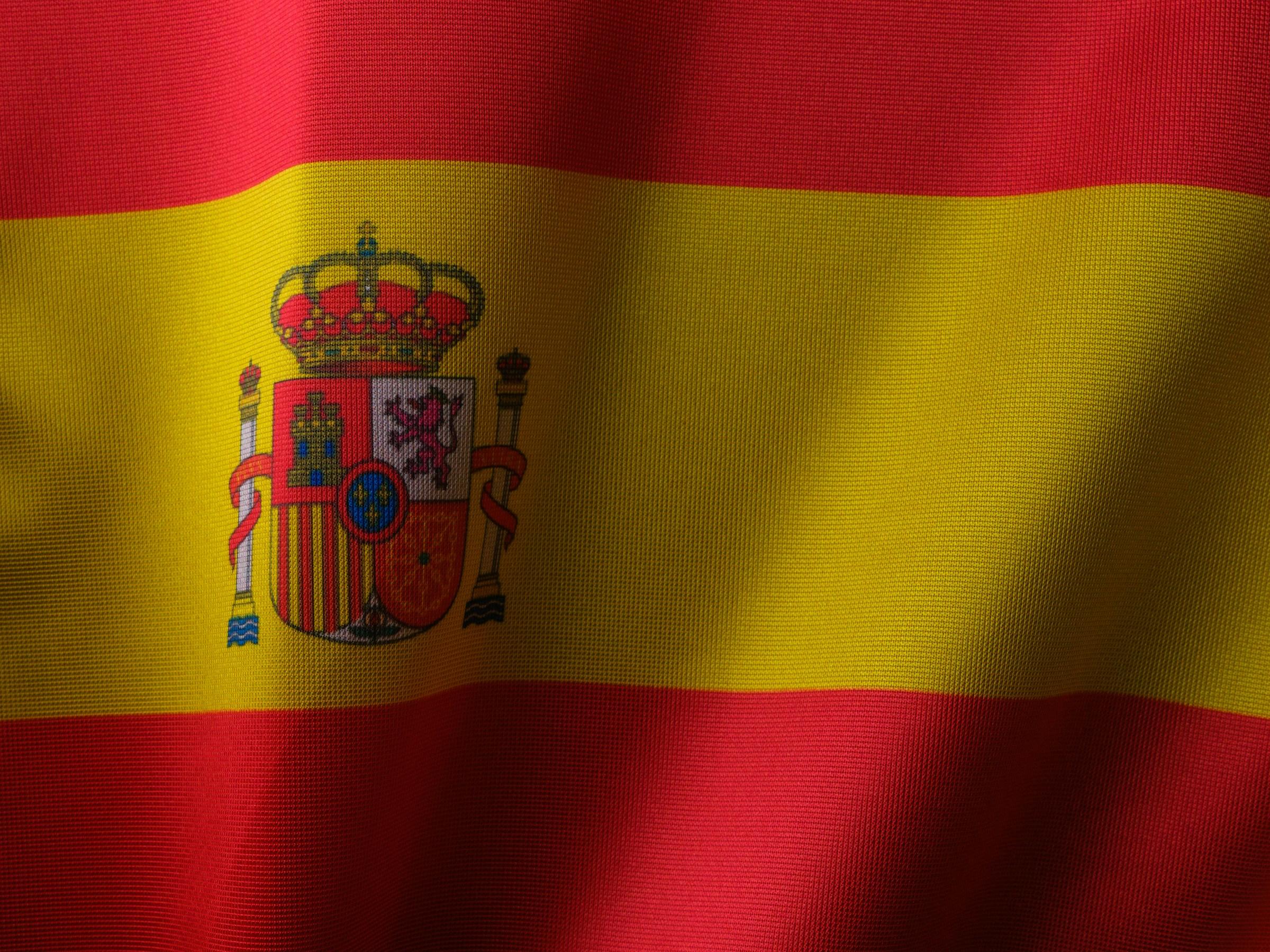 Primer plano del tejido texturado de la bandera española con su escudo.