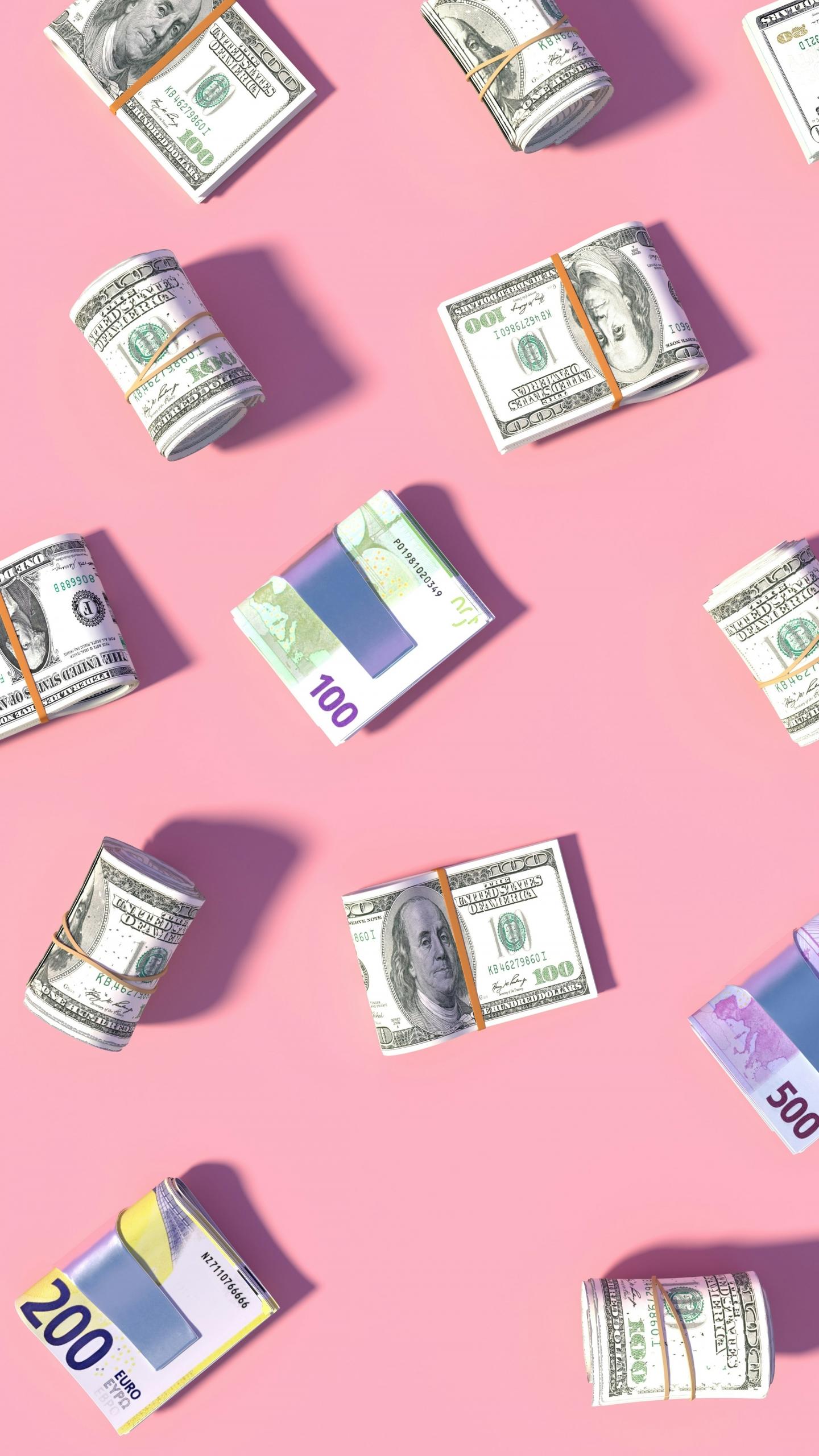 Varios billetes de euro y dólar esparcidos sobre fondo rosa.