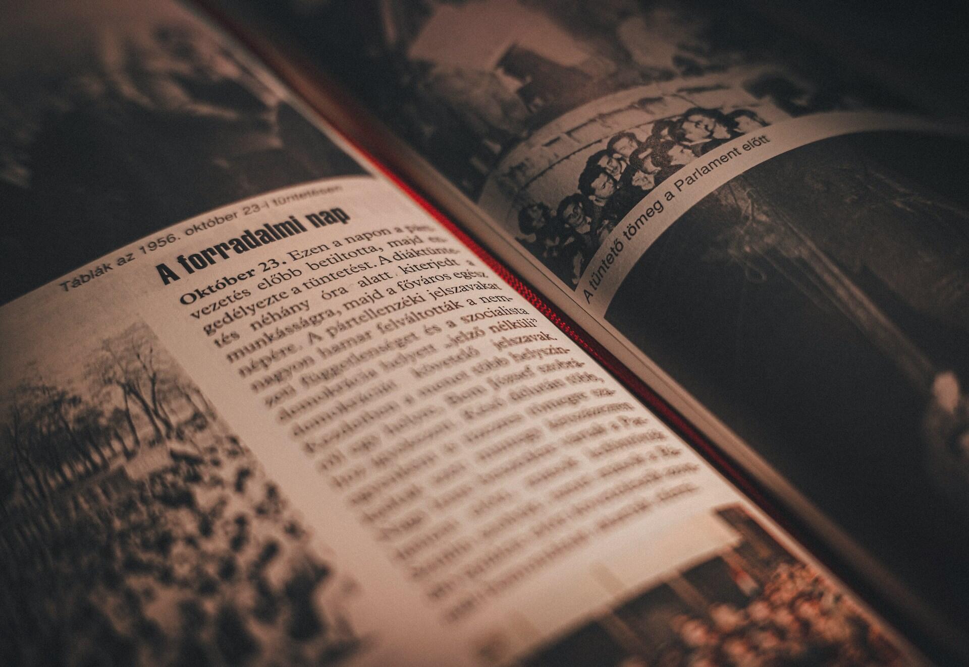 Libro abierto con páginas en tonos sepia que muestran texto en húngaro y fotografías históricas borrosas, lo que evoca una atmósfera nostálgica e histórica.