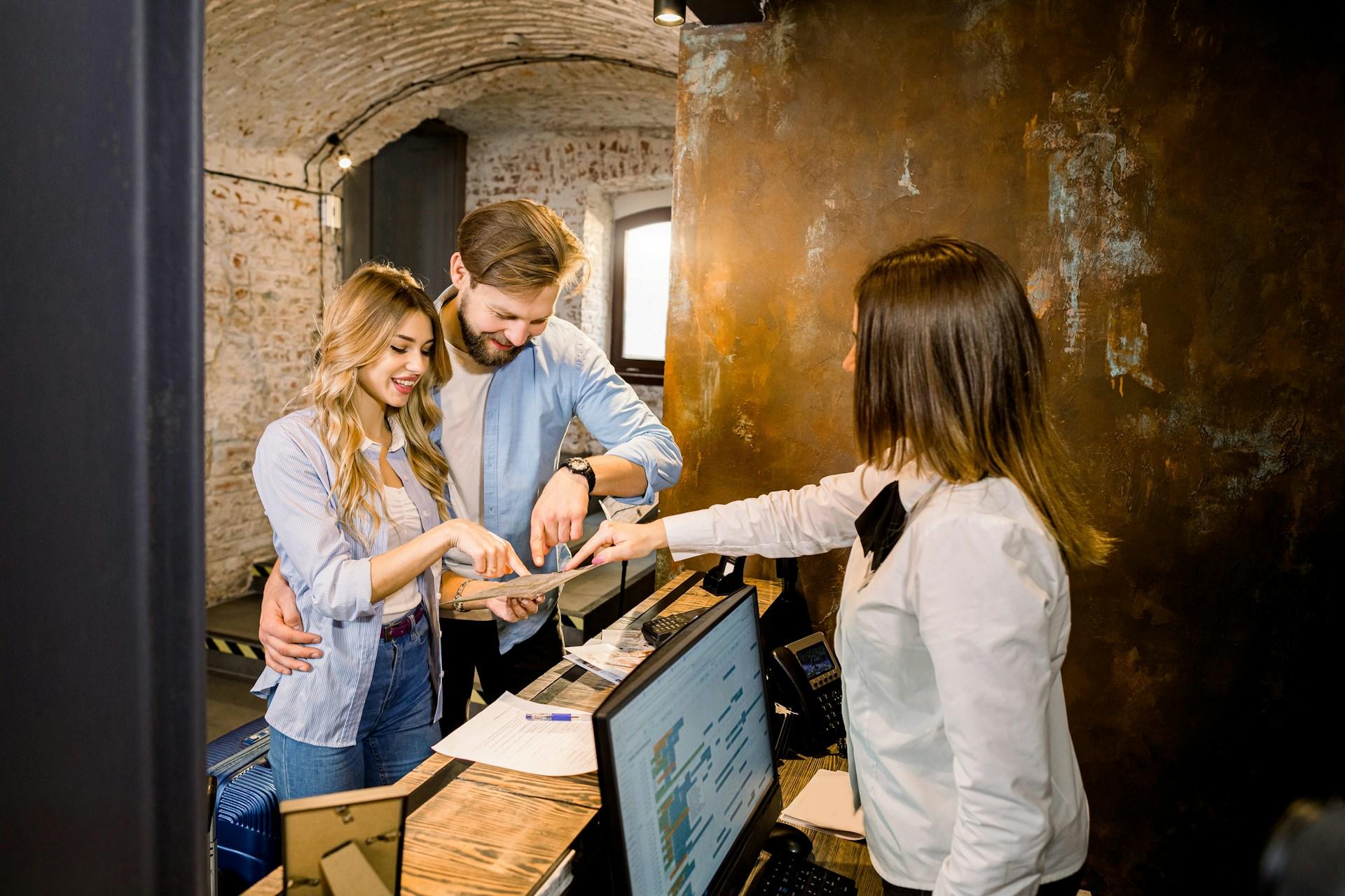 Tres individuos interactúan sobre un mostrador en una sala de estilo rústico con equipos electrónicos.