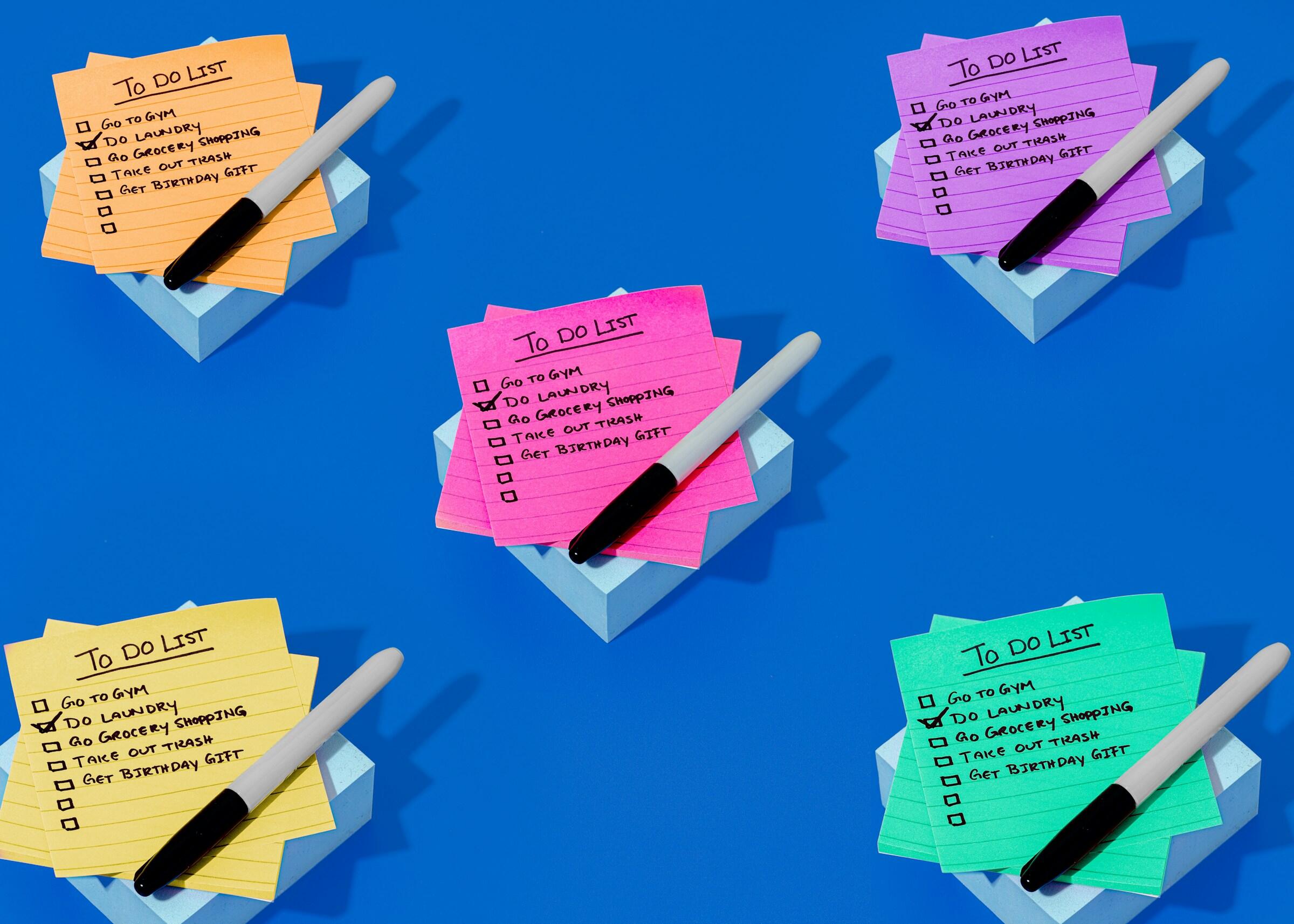 Notas adhesivas de colores con 'To Do List' y bolígrafos sobre fondo azul con aviones de papel.