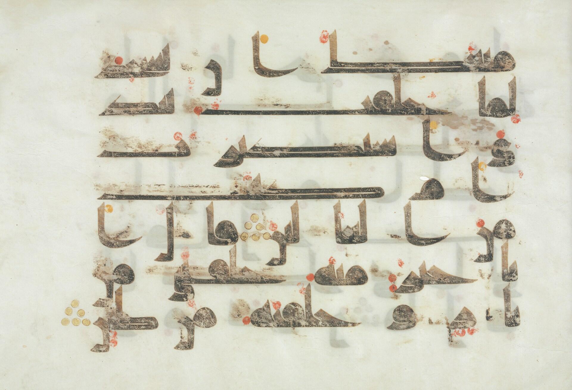 Manuscrito en caligrafía árabe descolorida sobre pergamino, dispuesto en filas con letras negras y marrones, signos diacríticos rojos y dorados, y textura desgastada.