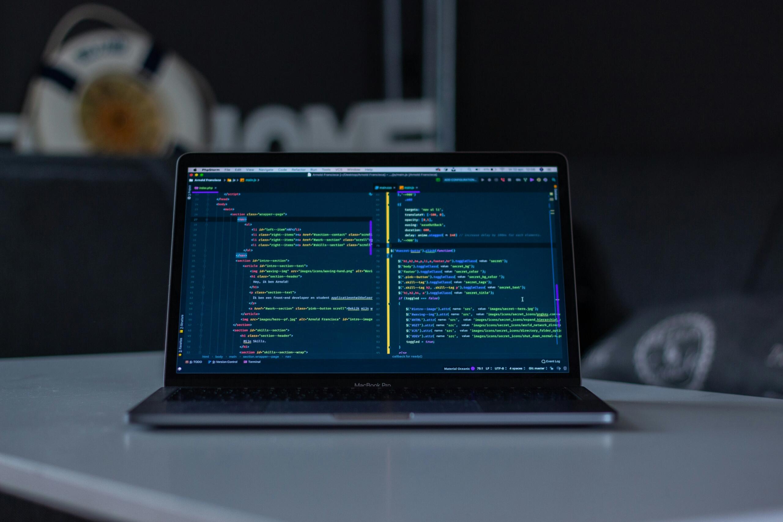 Un portátil con código en la pantalla, reposando sobre una mesa de trabajo. 