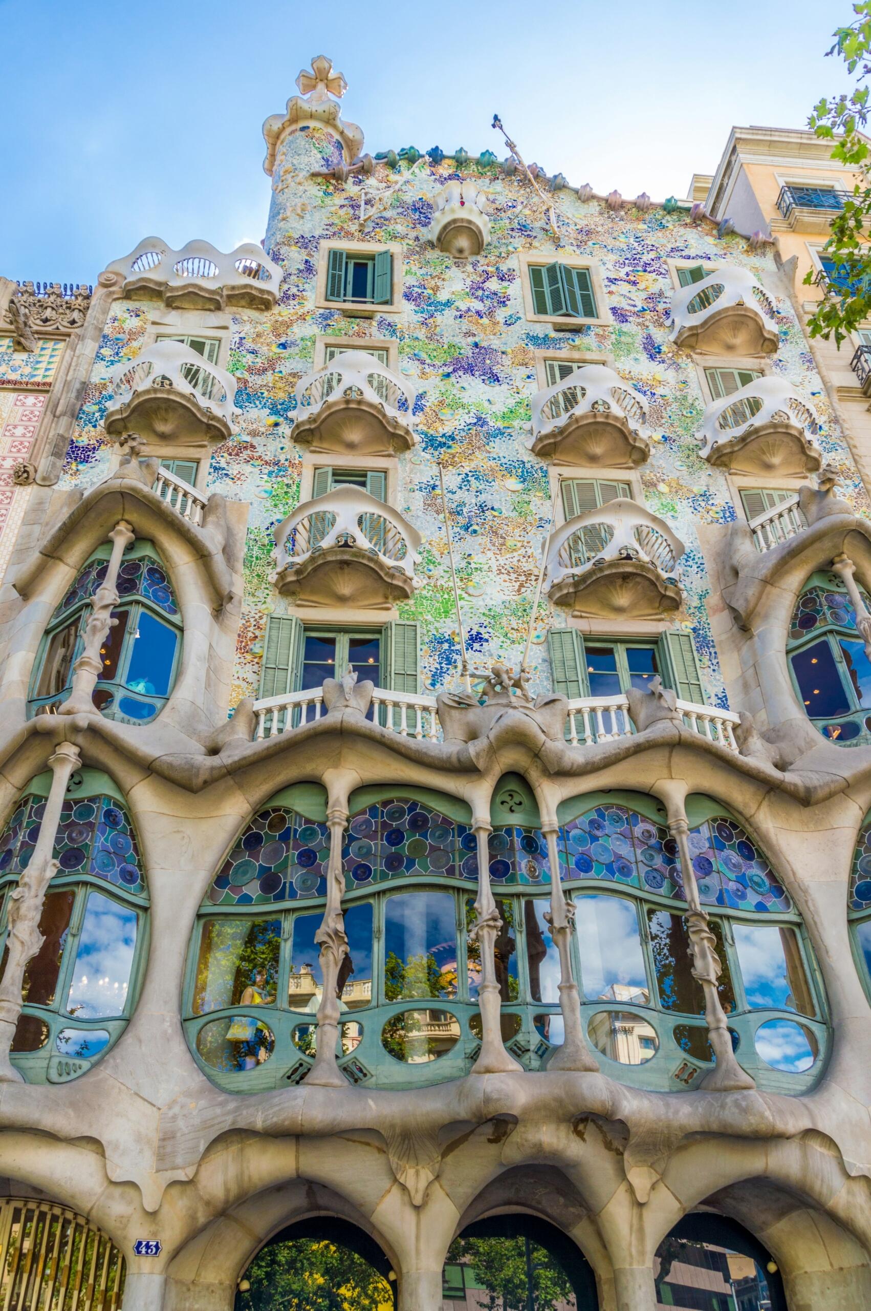 Fachada de la Casa Batlló de Barcelona, con coloridos mosaicos, formas orgánicas e intrincados balcones, muestra de la arquitectura única de Gaudí.