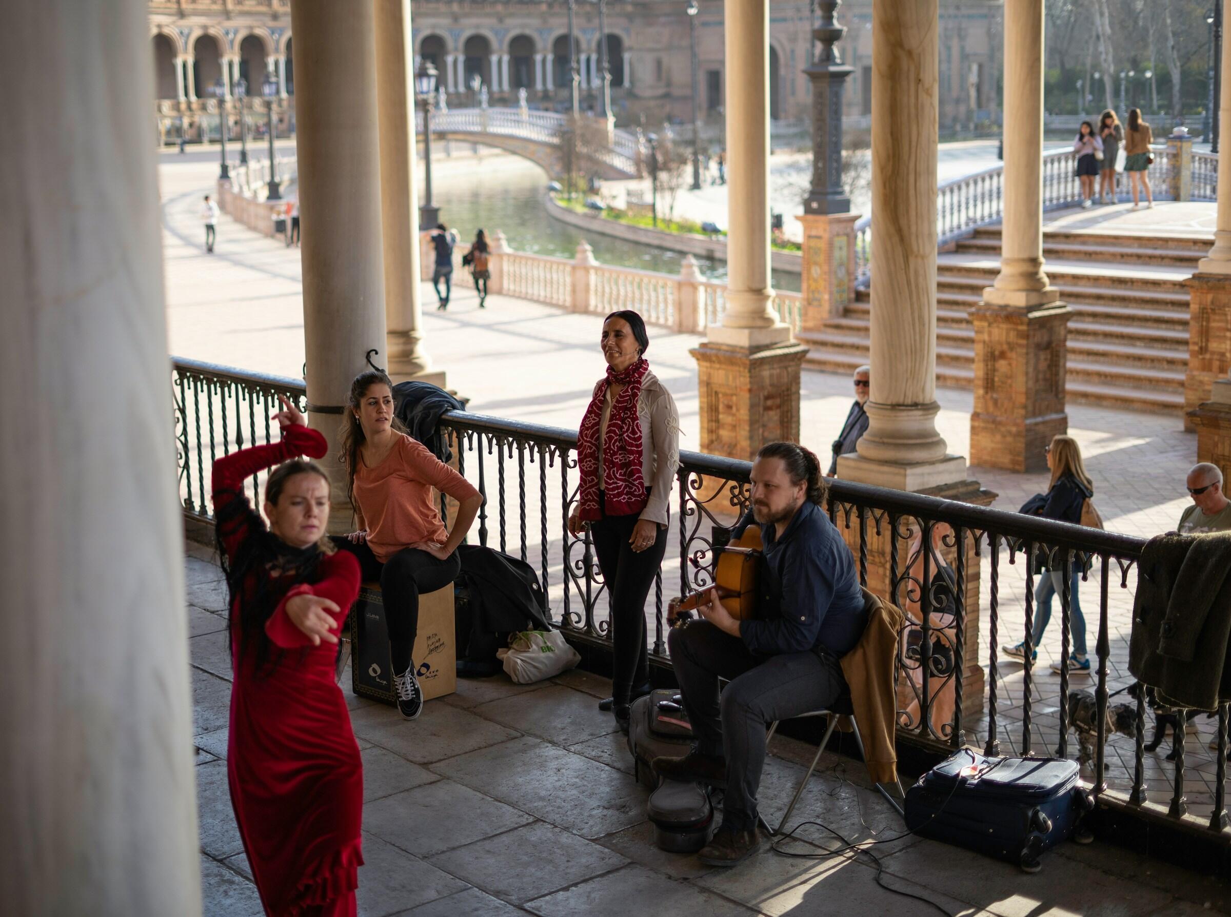Un animado espectáculo callejero con bailarines y músicos, con el telón de fondo de una plaza histórica.