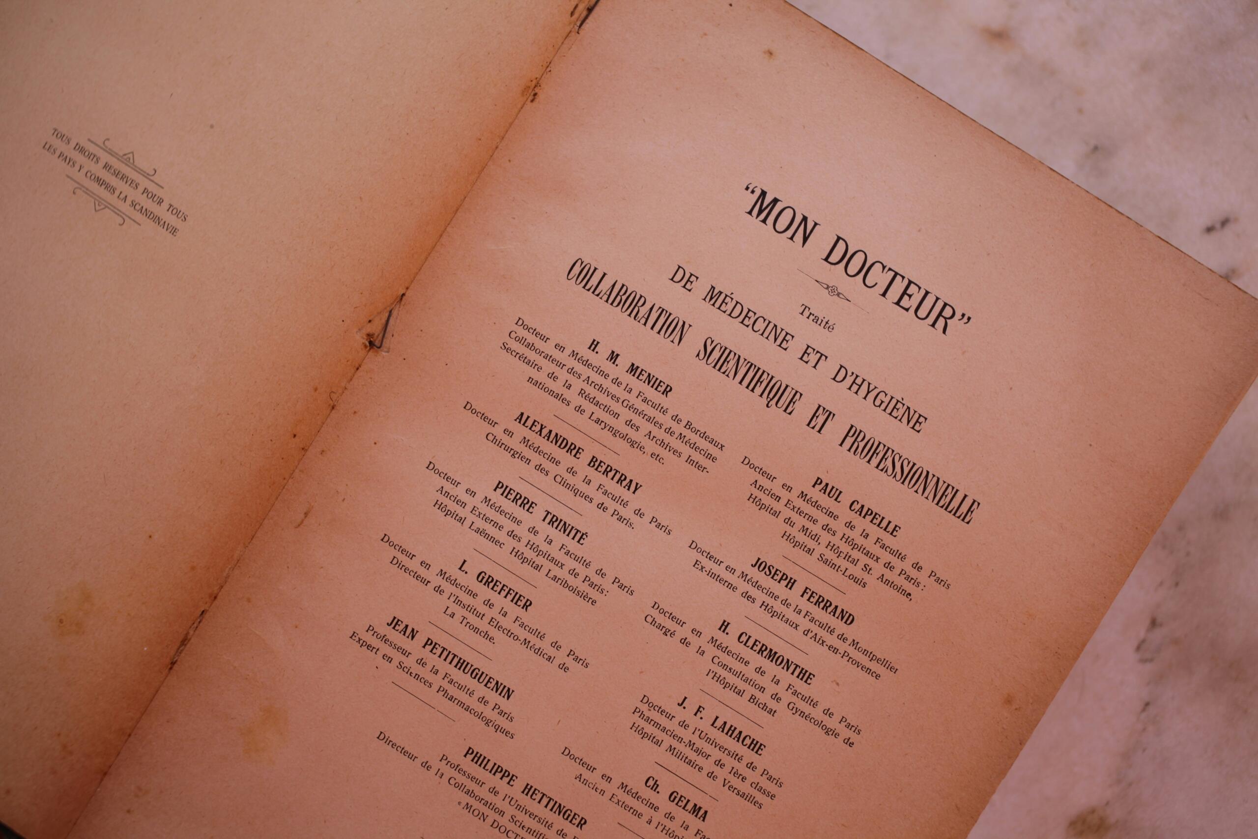 Página de un antiguo libro de medicina titulado «Mon Docteur» con los nombres y títulos de los colaboradores, sobre papel envejecido y texturado.
