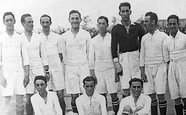 Fotografía histórica en blanco y negro del equipo de de futbol de real madrid posando juntos, con uniformes a juego, con diez jugadores de pie y tres sentados.