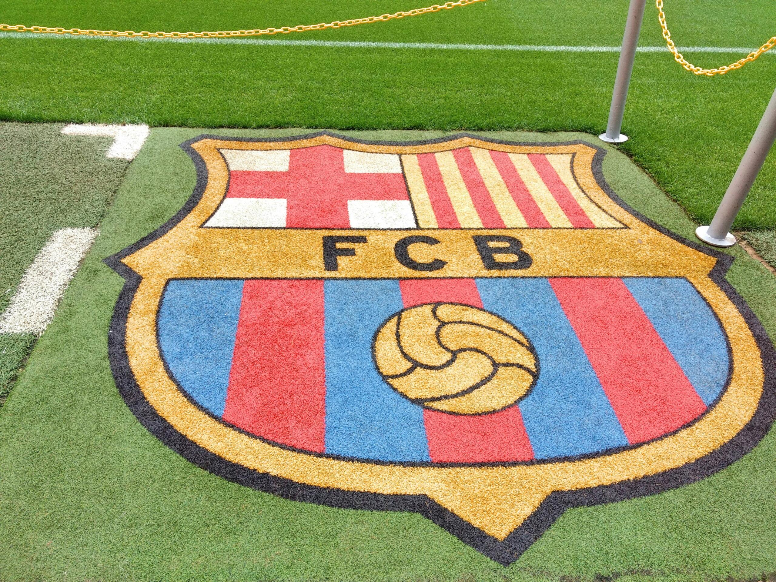 escudo del futbol club barceonal en el cesped del campo