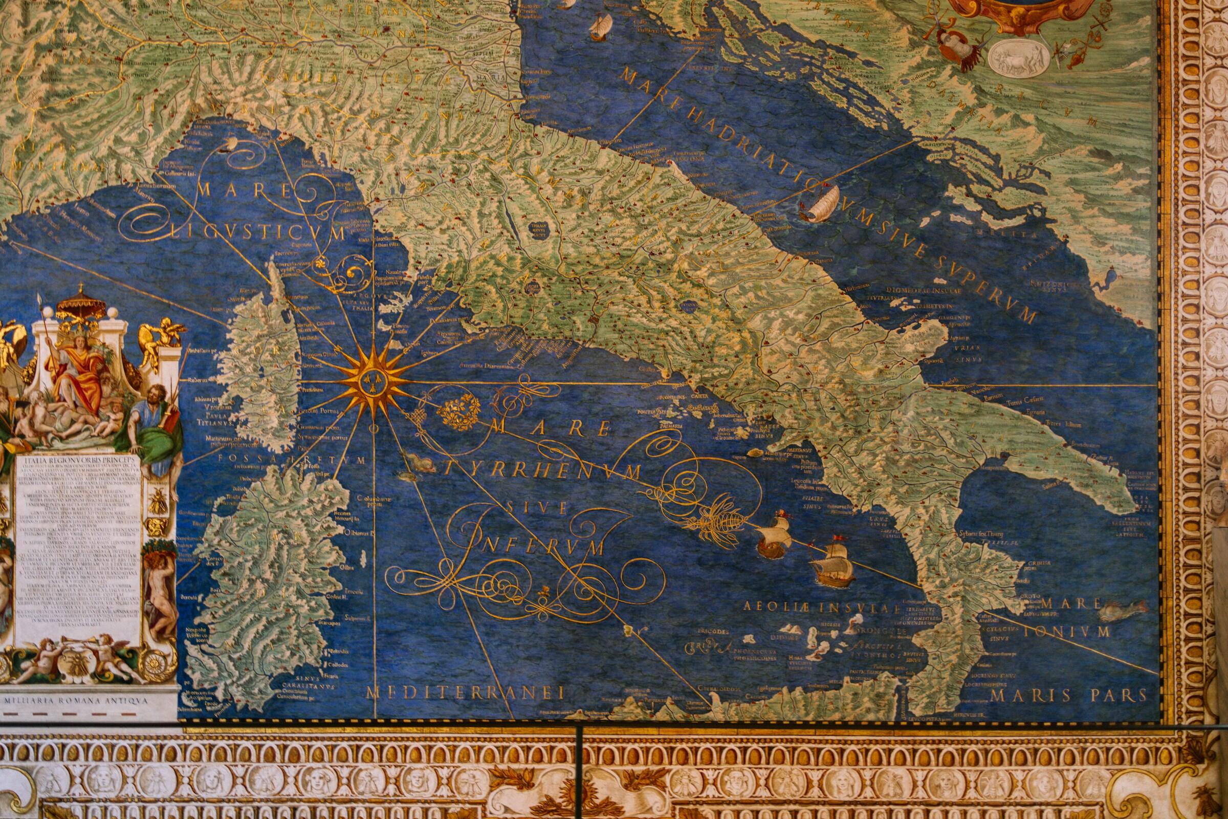 Mapa antiguo de Italia, con costa y topografía detalladas y elementos decorativos como una rosa de los vientos y bordes ornamentados.