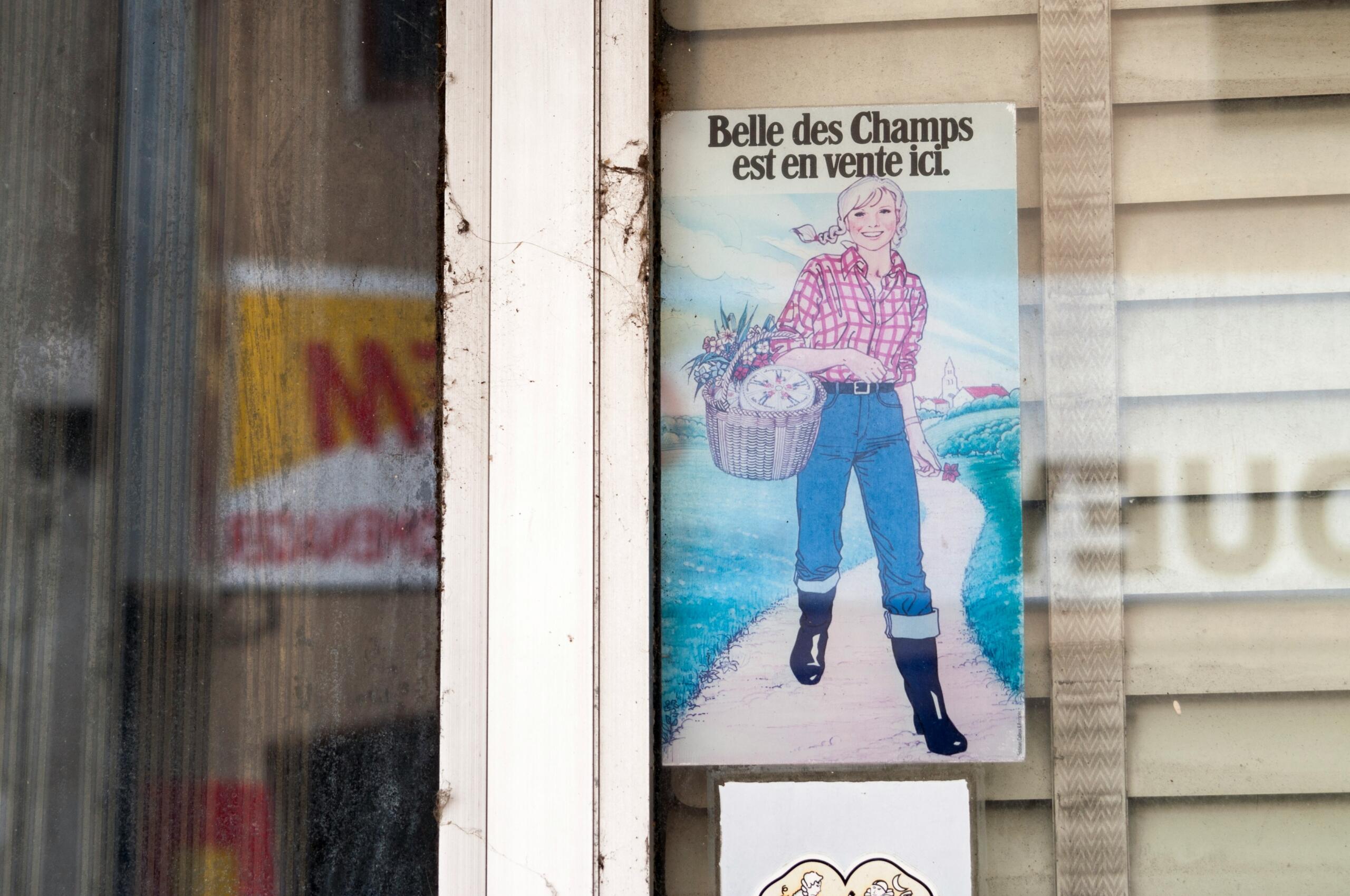Colorido cartel de época en el que aparece una persona con atuendo agrícola sosteniendo una cesta, promocionando la venta de «Belle des Champs».